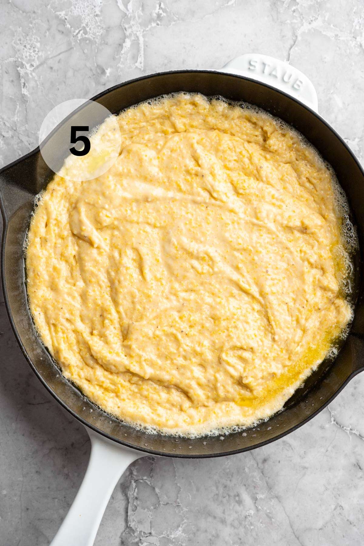 Cornbread batter in an iron skillet.