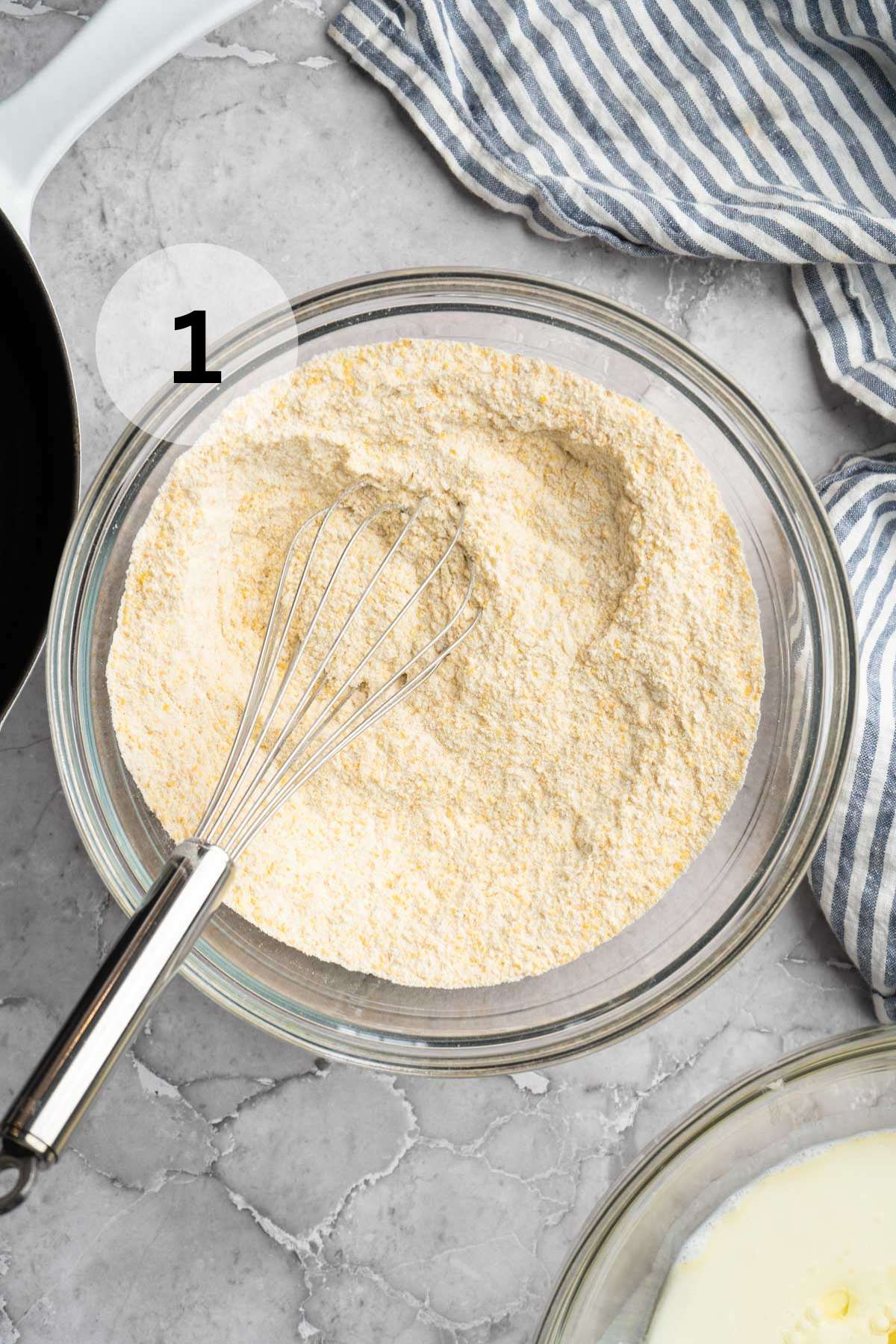 Combining flour, sugar and cornmeal in a large bowl with a whisk.