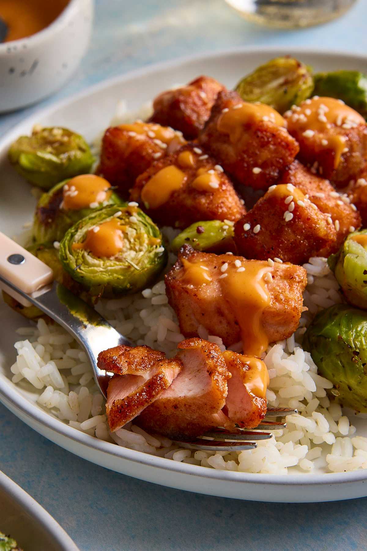 Salmon bites served over rice with Brussels sprouts.