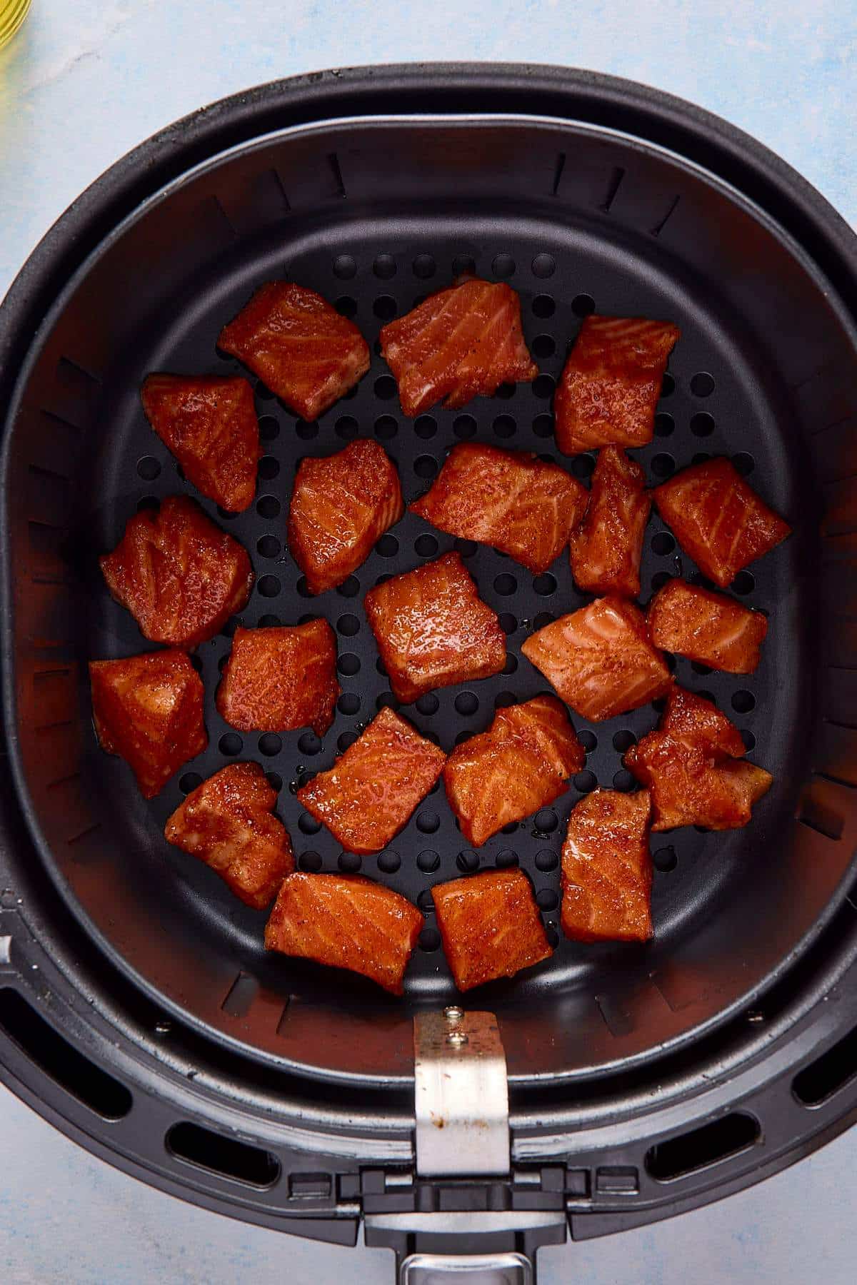 Pieces of salmon in an air fryer.