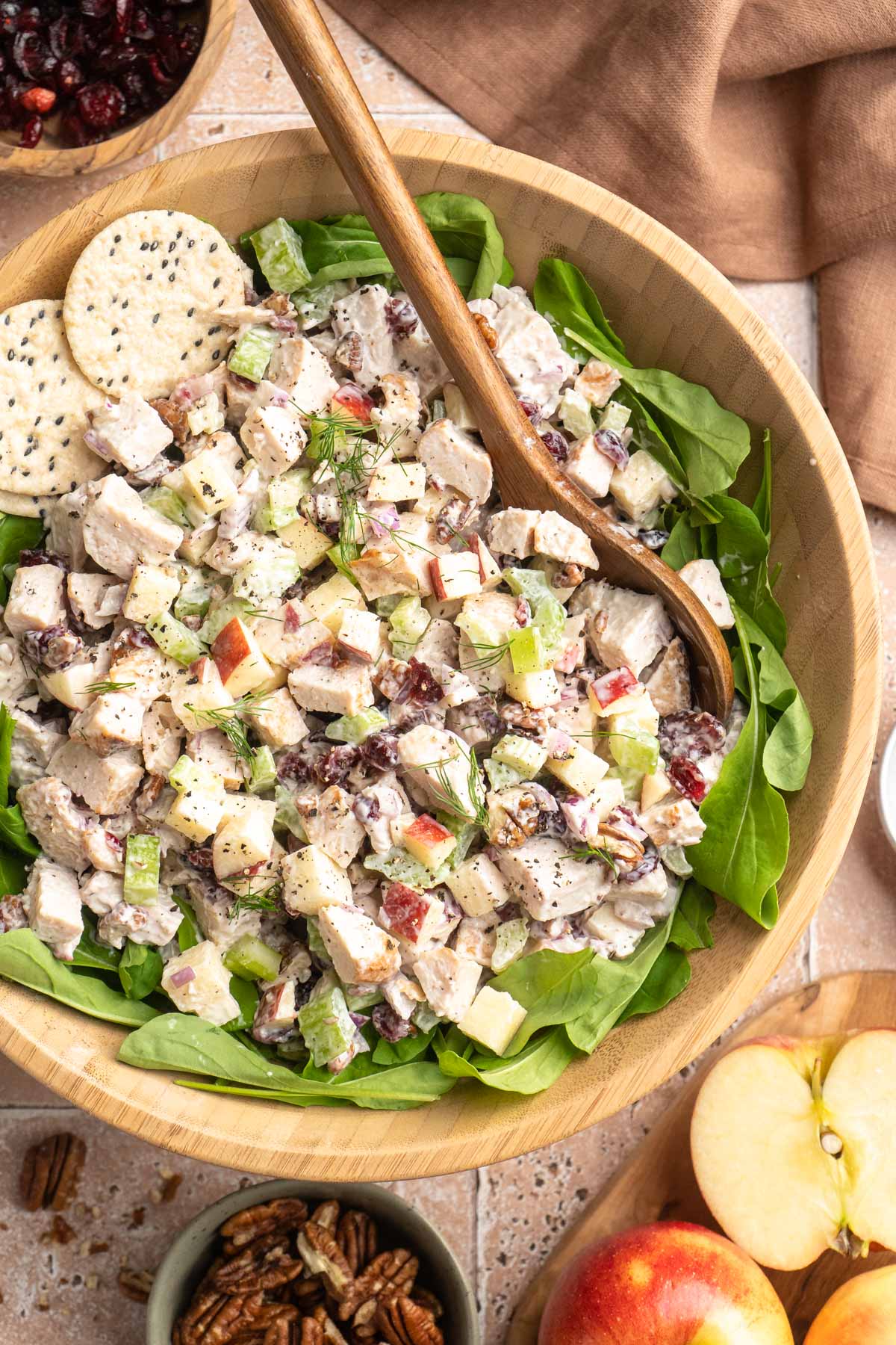 Chicken salad with apples in a bowl with lettuce.
