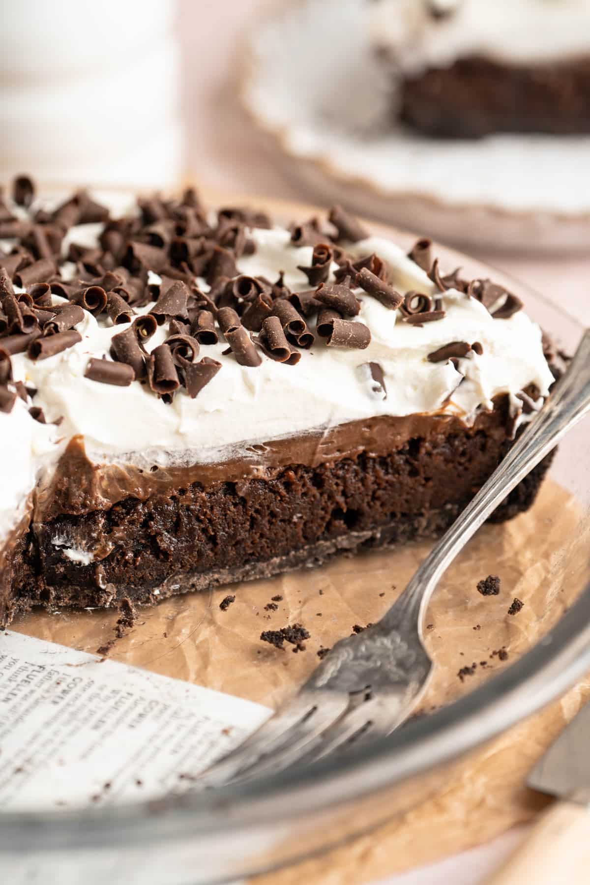 Pie with chocolate and whipped cream layers sliced in a pie plate.