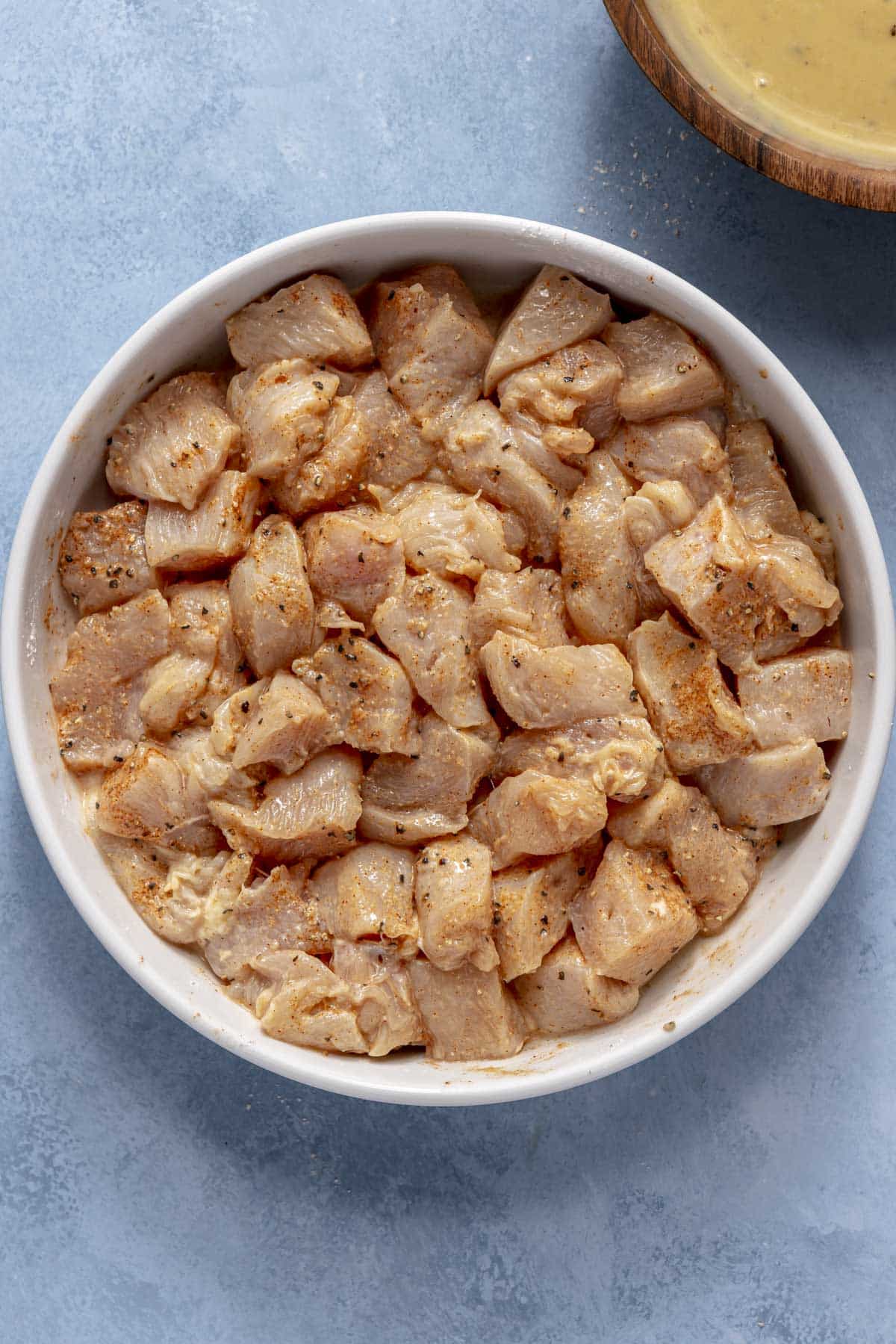 Tossing chicken pieces in seasoning blend.