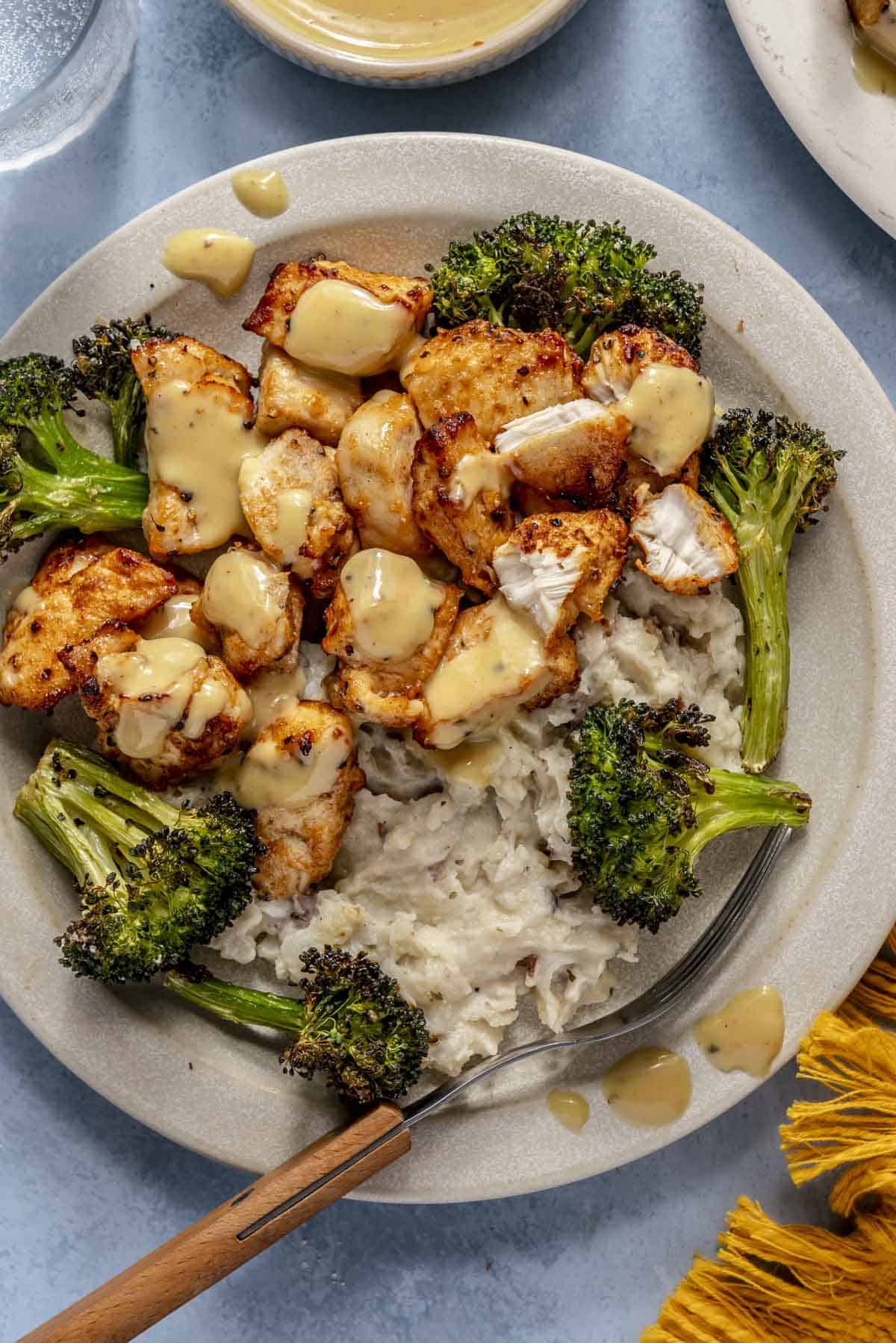 Air fryer chicken bites served with broccoli and mashed potatoes.