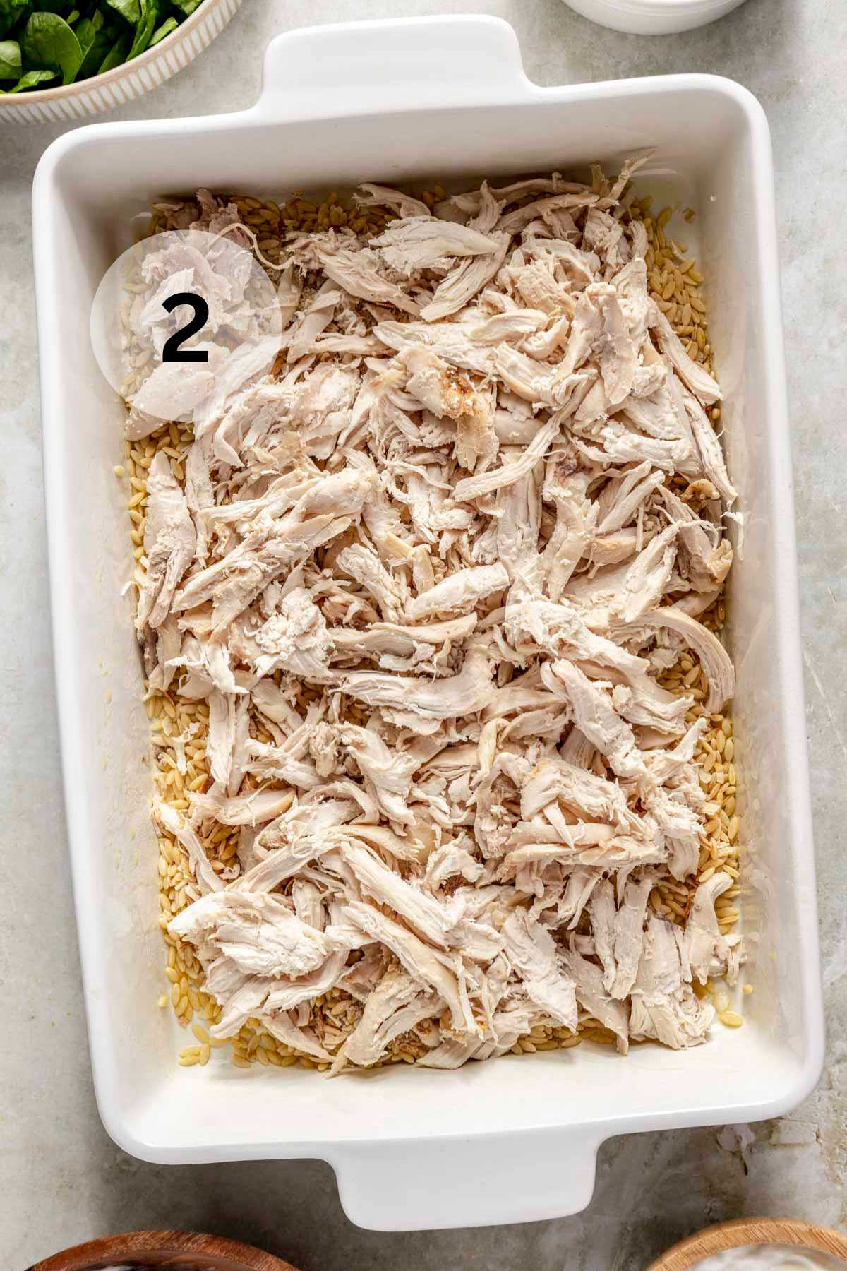 Shredded chicken in a 9x13-inch baking dish.
