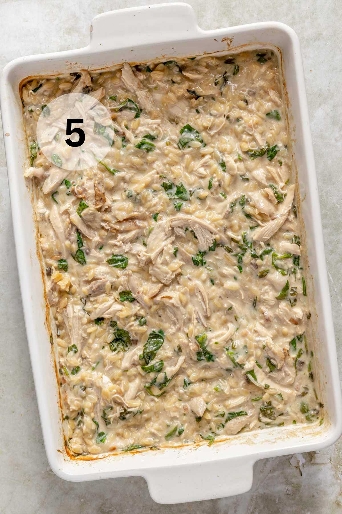 Baked chicken orzo bake in a white casserole dish.