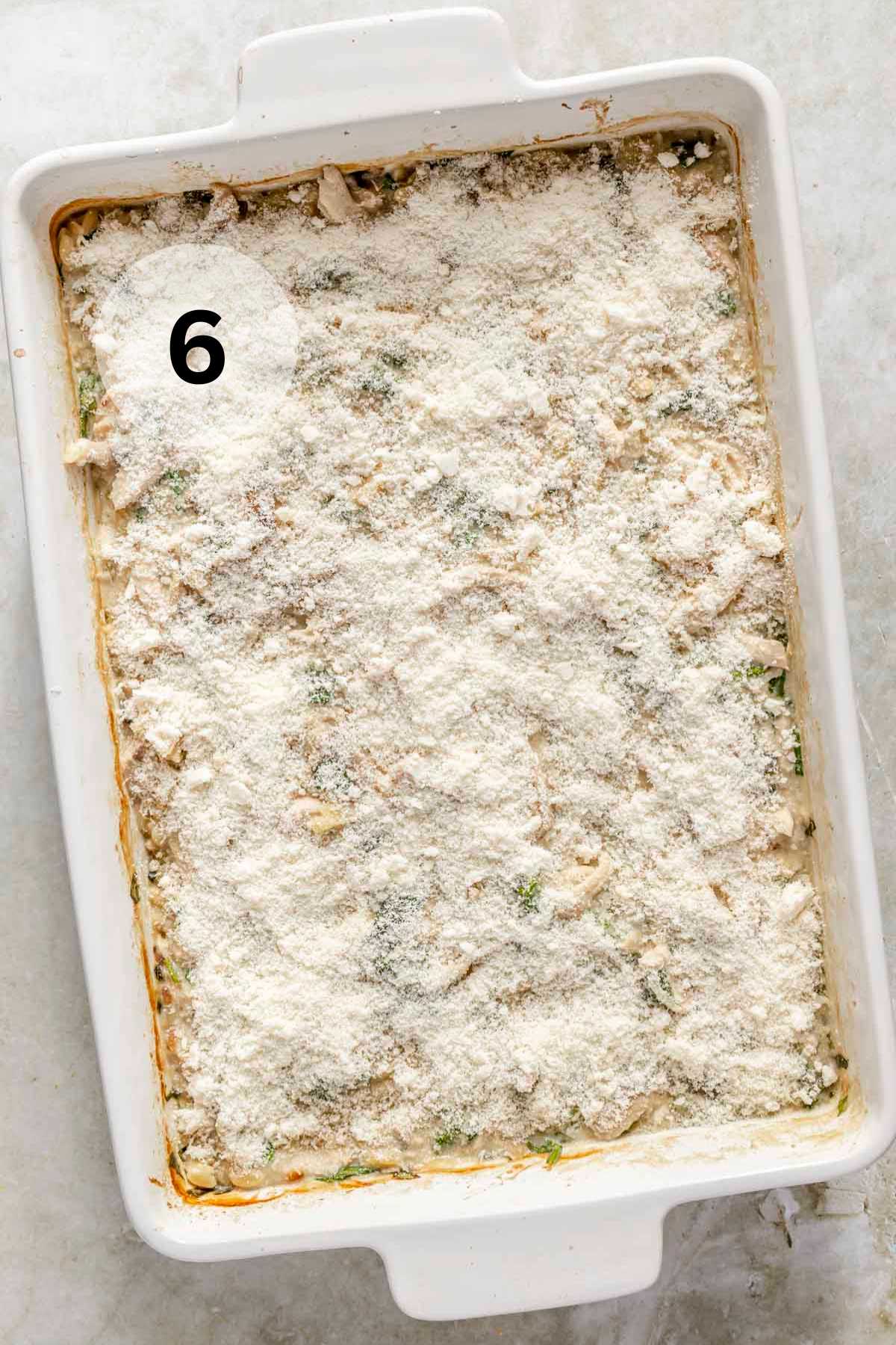 Topping casserole with parmesan cheese.
