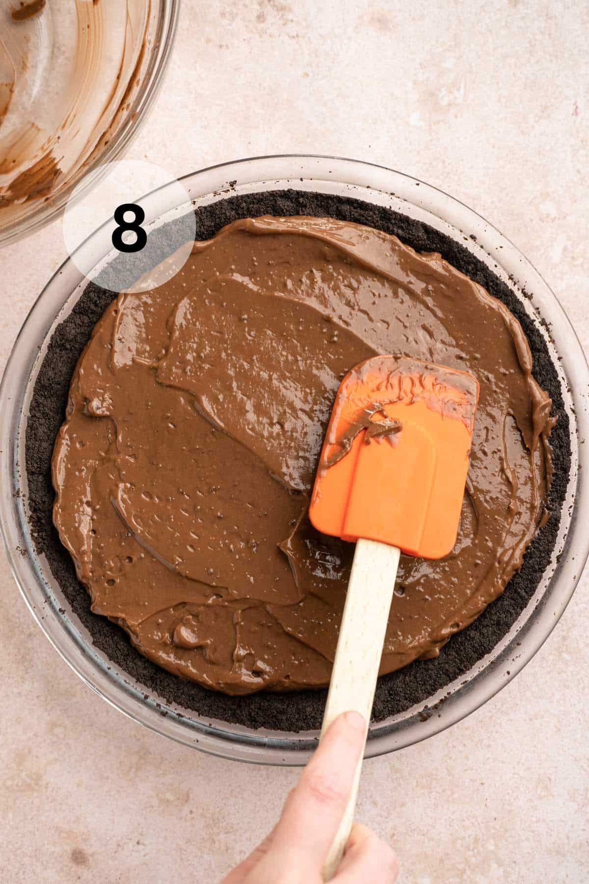 Spreading pudding mixture over pie.