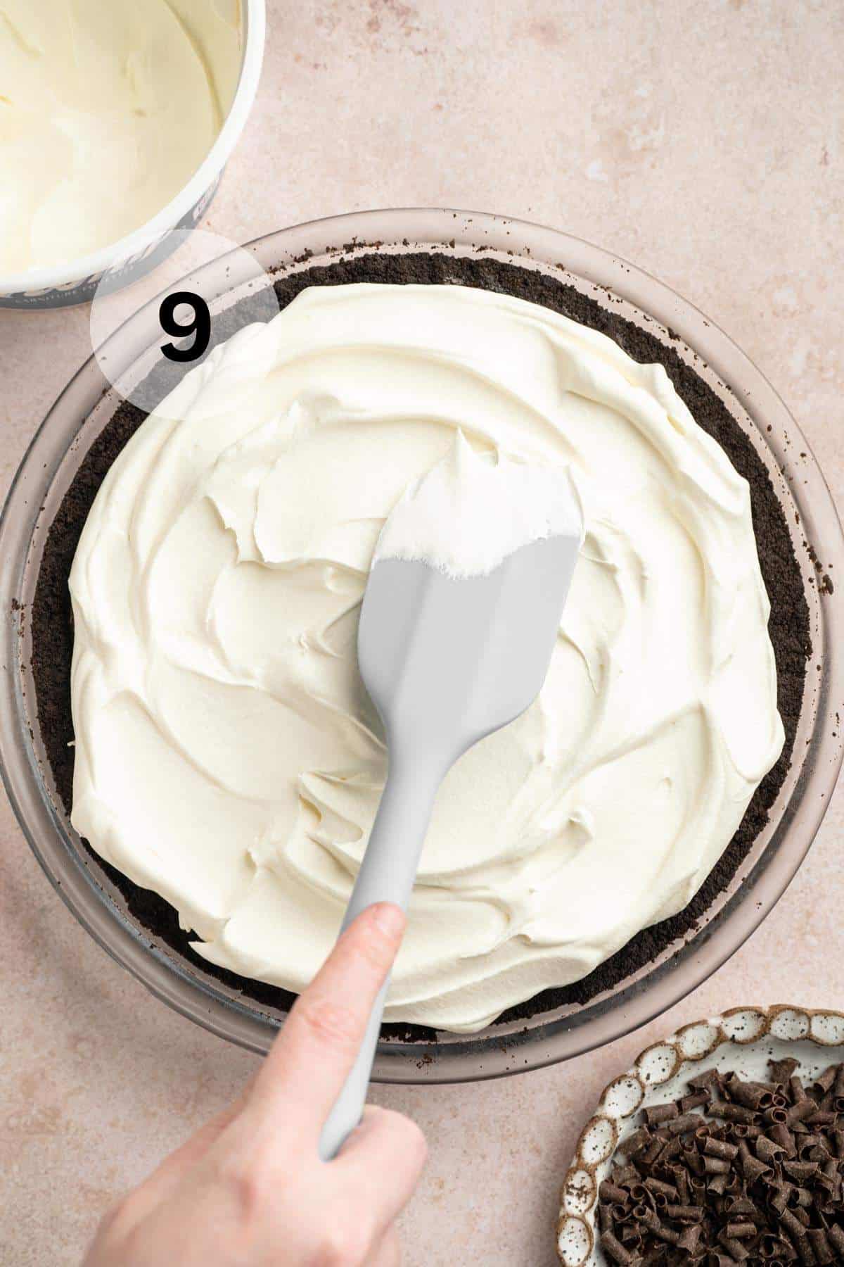 Spreading Cool Whip over pie.