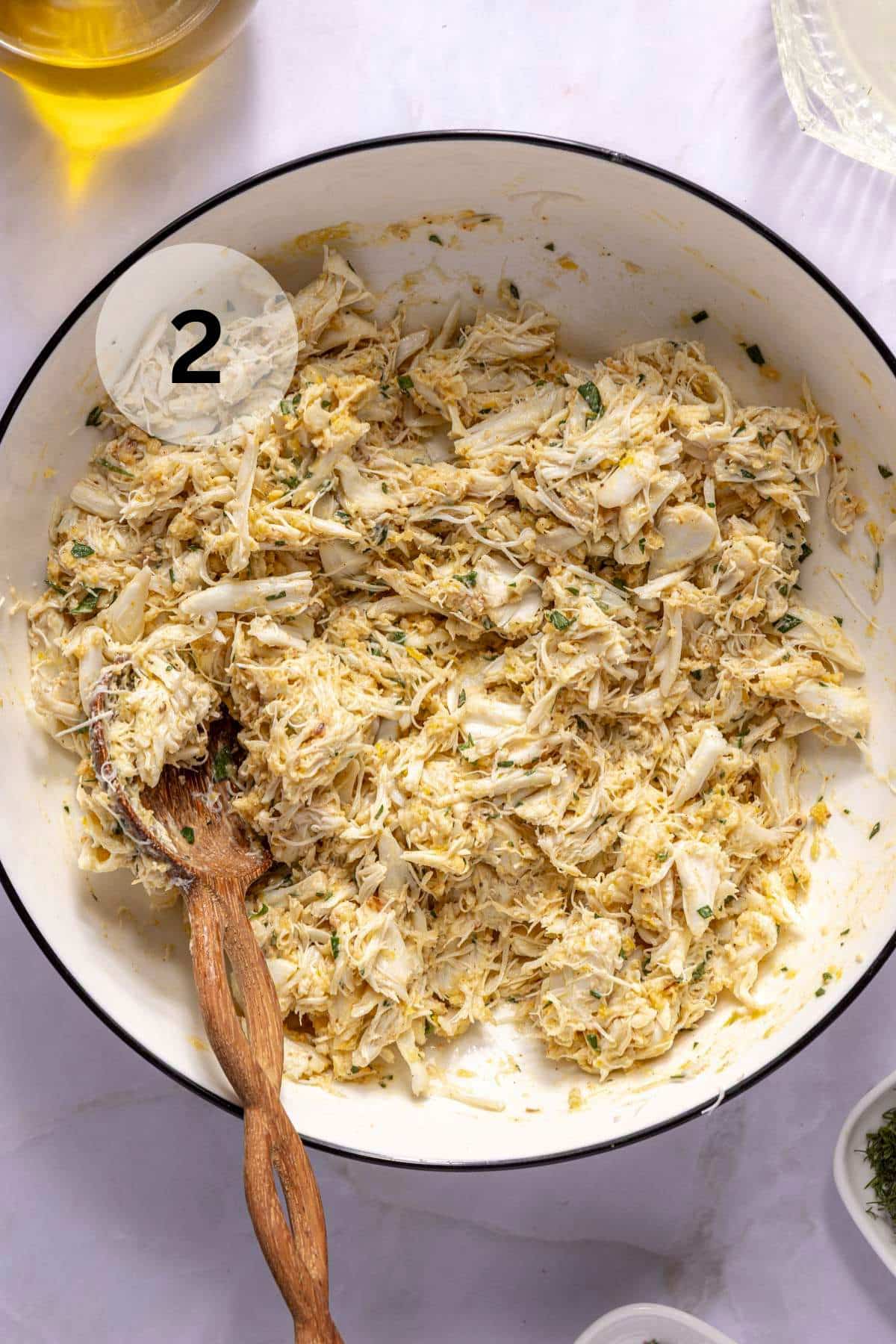 Stirring the crab meat with the binding mixture.