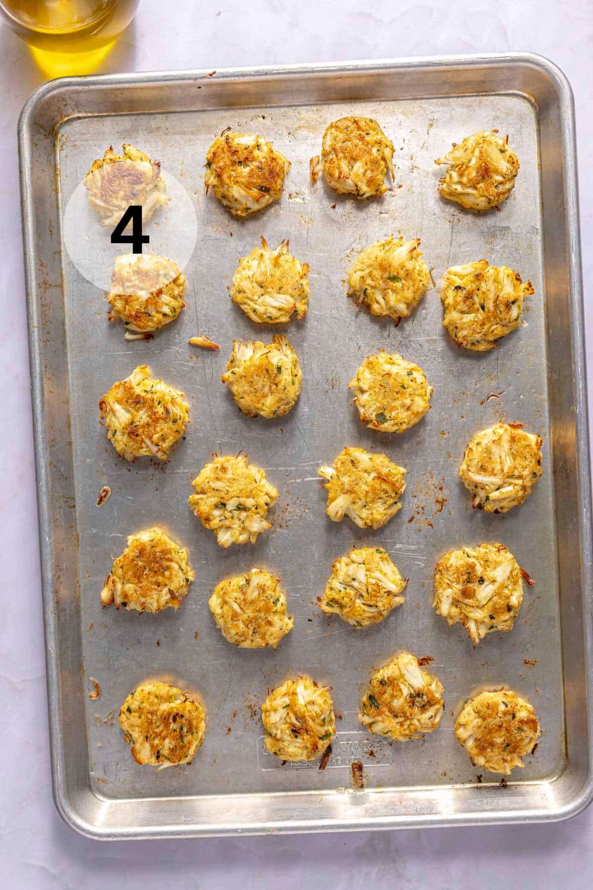Baked crab cakes on a sheet pan.