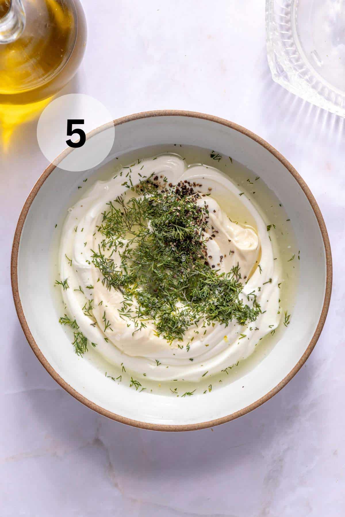 Combining mayo, greek yogurt lemon juice and dill in a small bowl.