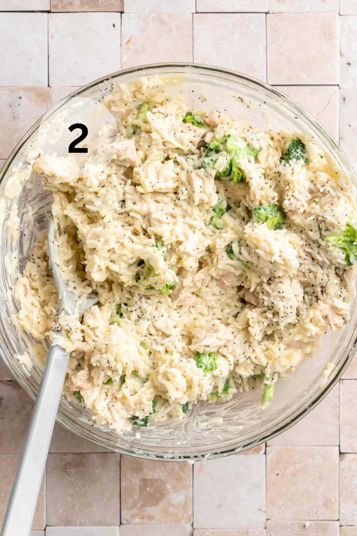 Stirring together broccoli, chicken, cream of chicken soup, sour cream, rice, and poppy seeds in a large bowl.