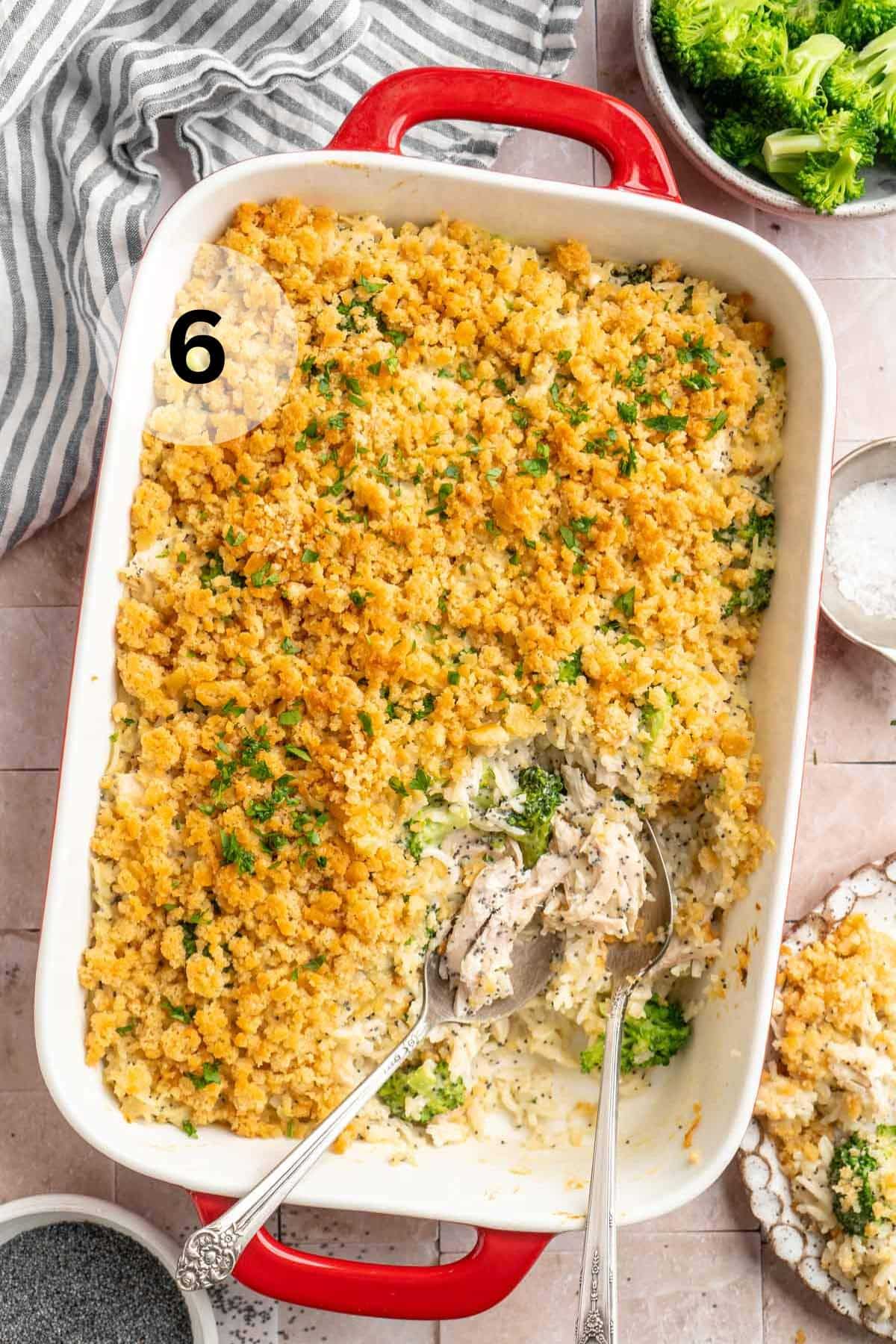 Poppy seed chicken being served with serving spoons.
