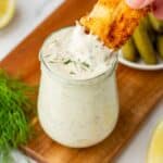 Dipping a fish stick into tartar sauce.