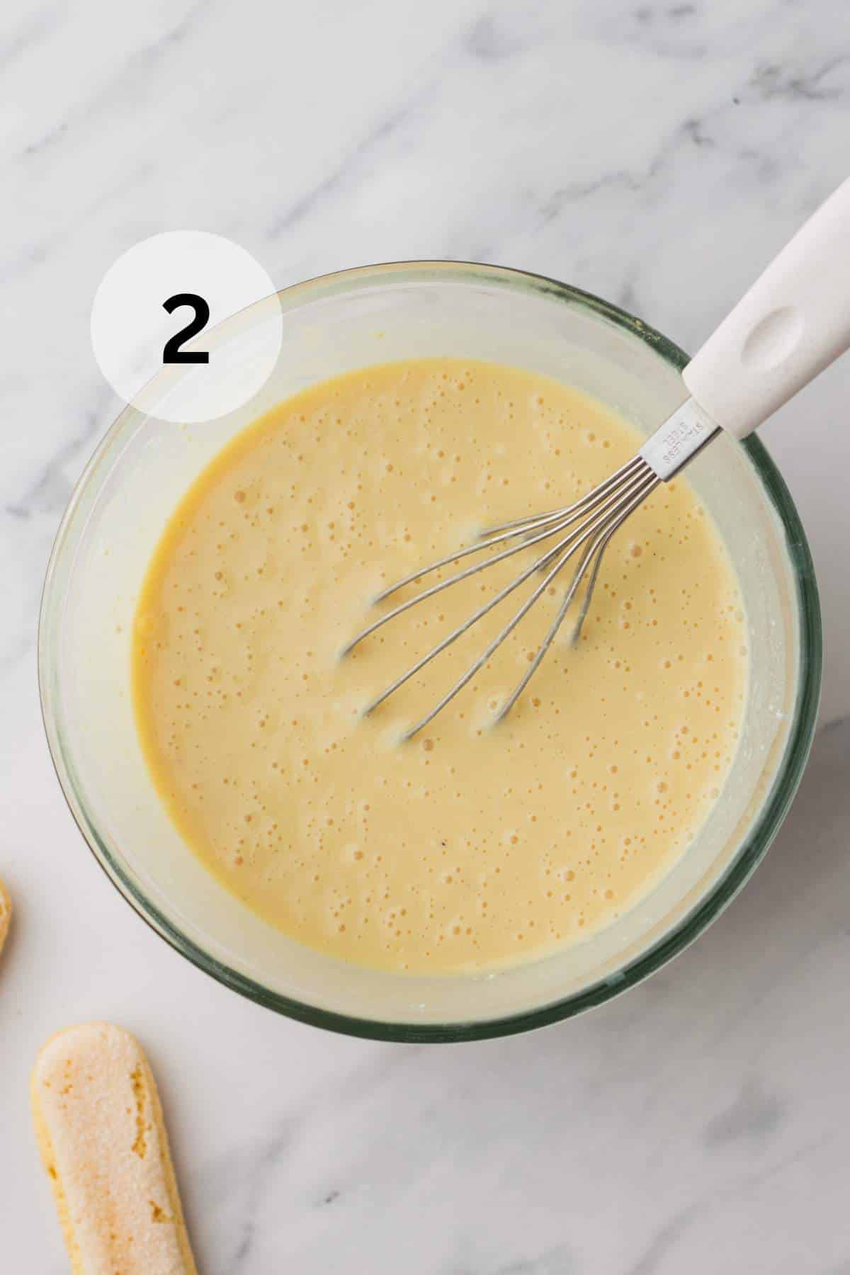 Whisking sweetened condensed milk, mascarpone, vanilla paste, and coffee liqueur.