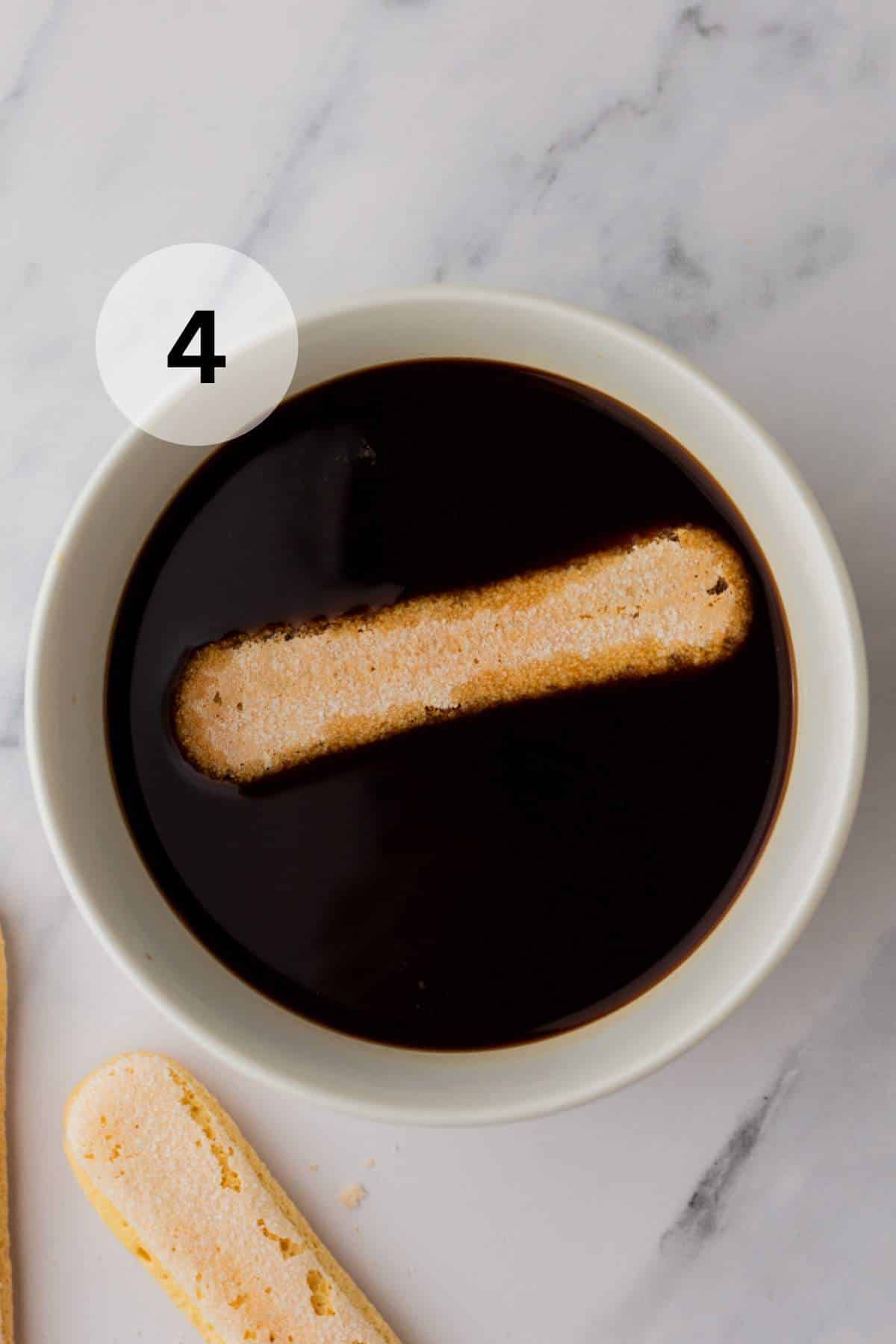 Dipping ladyfinger cookie into espresso.