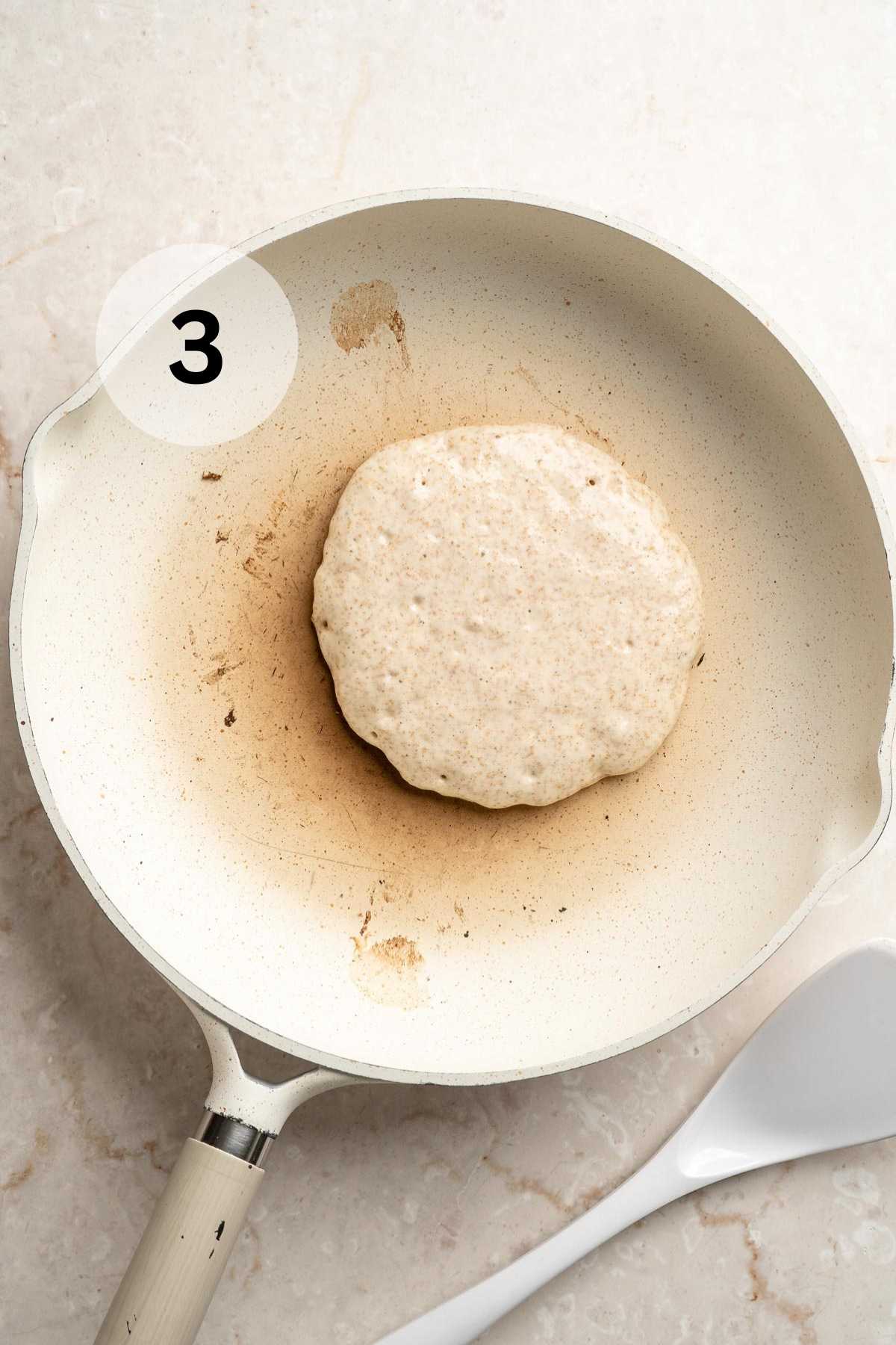 Pancake cooking in a skillet.