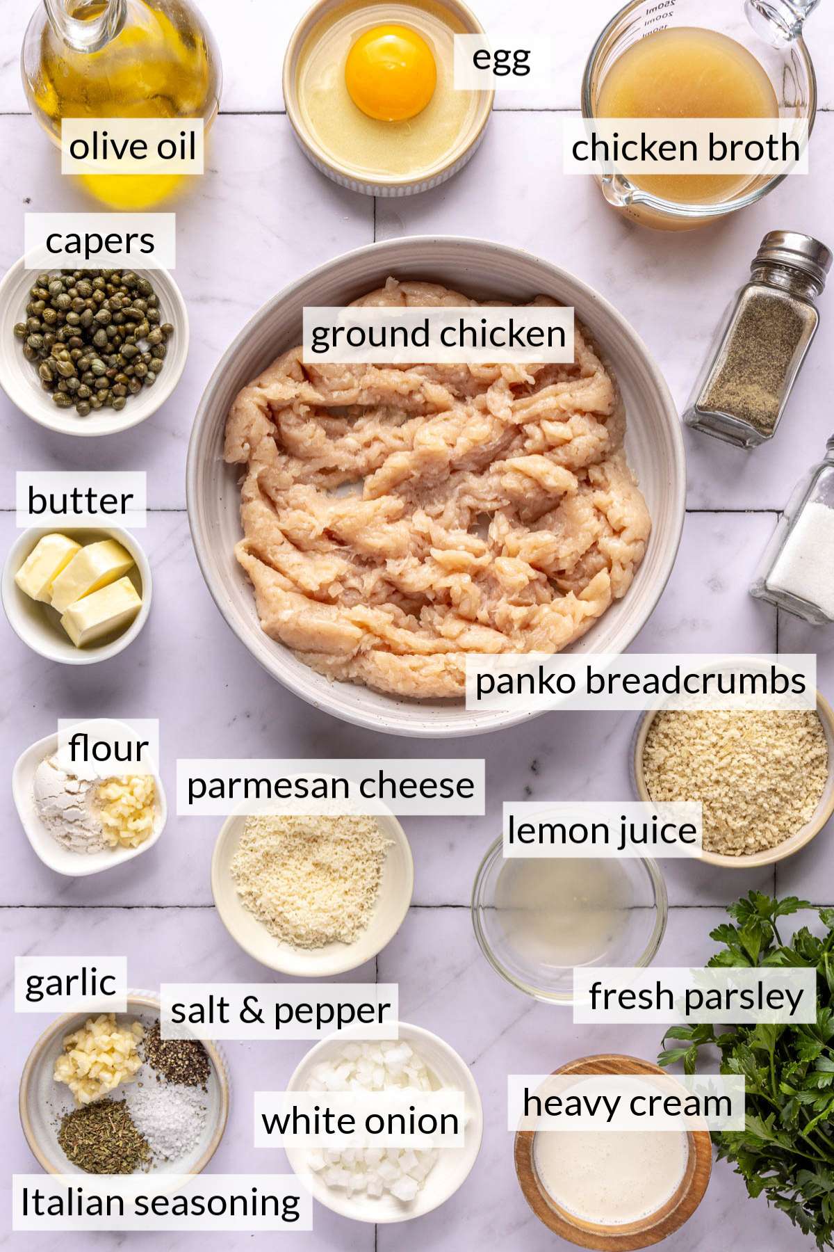 Bowls with ground chicken, parmesan, breadcrumbs, cream, seasonings, butter, capers and chicken broth.