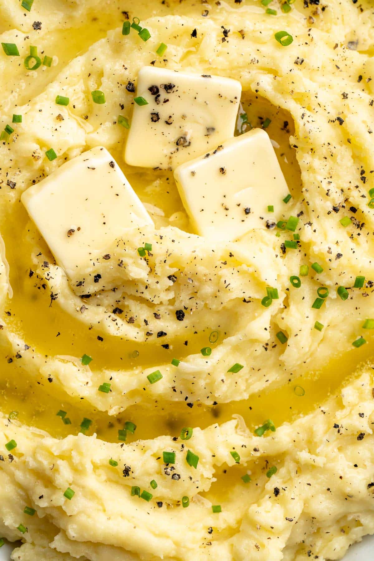 Buttery mashed potato recipe served with freshly ground black pepper and chives.
