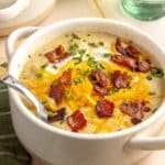 Potato soup topped with bacon and shredded cheese.