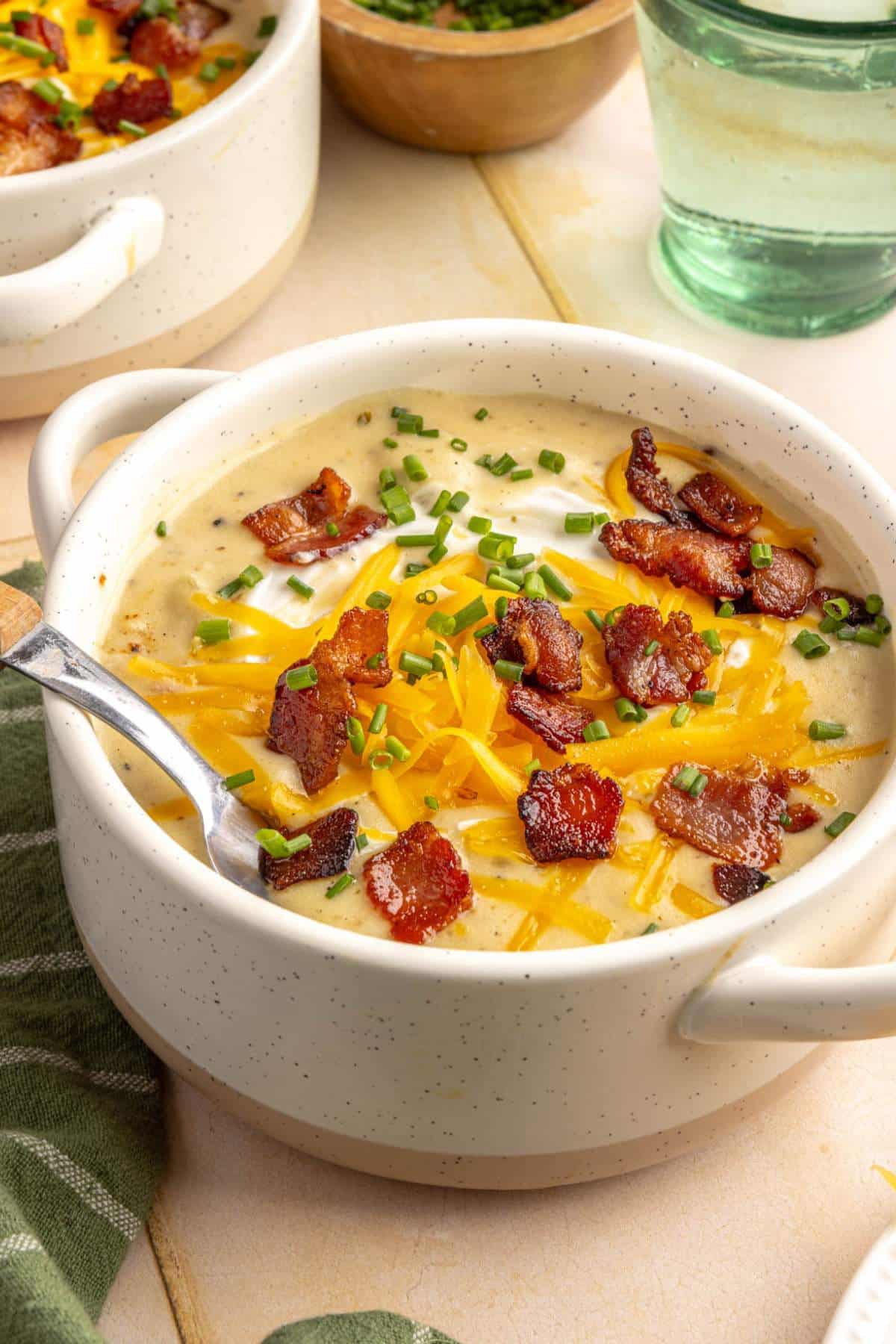 Potato soup topped with bacon and shredded cheese.