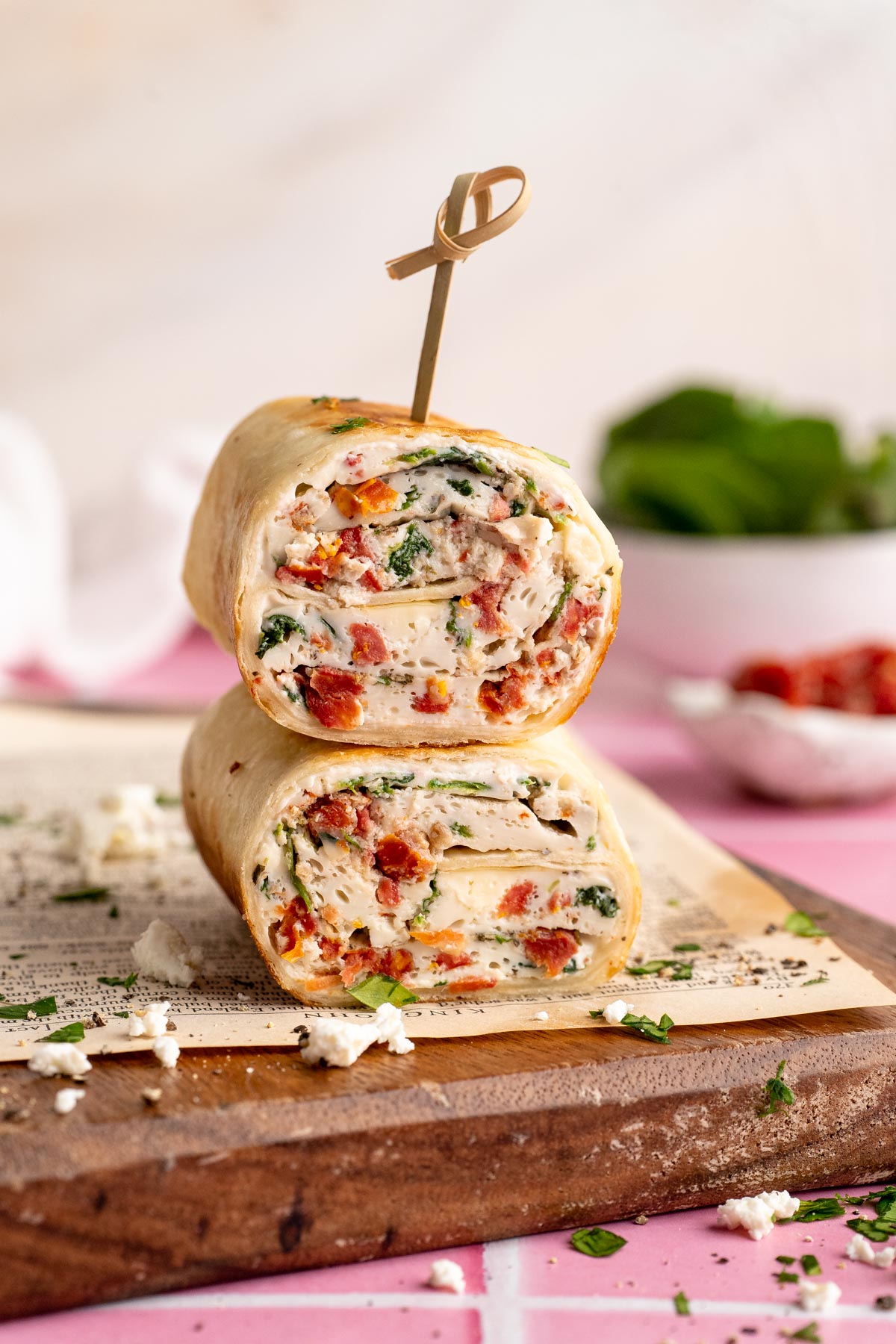 A Starbucks spinach feta wrap cut in half and stacked with a toothpick through the top.