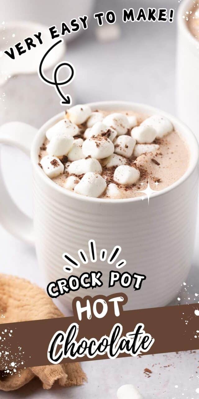 Mug of hot cocoa topped with mini marshmallows and a sprinkle of cocoa powder.