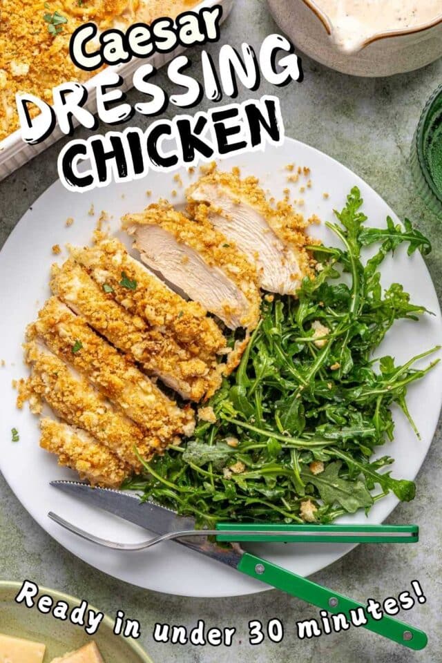 Breaded caesar dressing chicken on a white plate with a simple arugula salad.