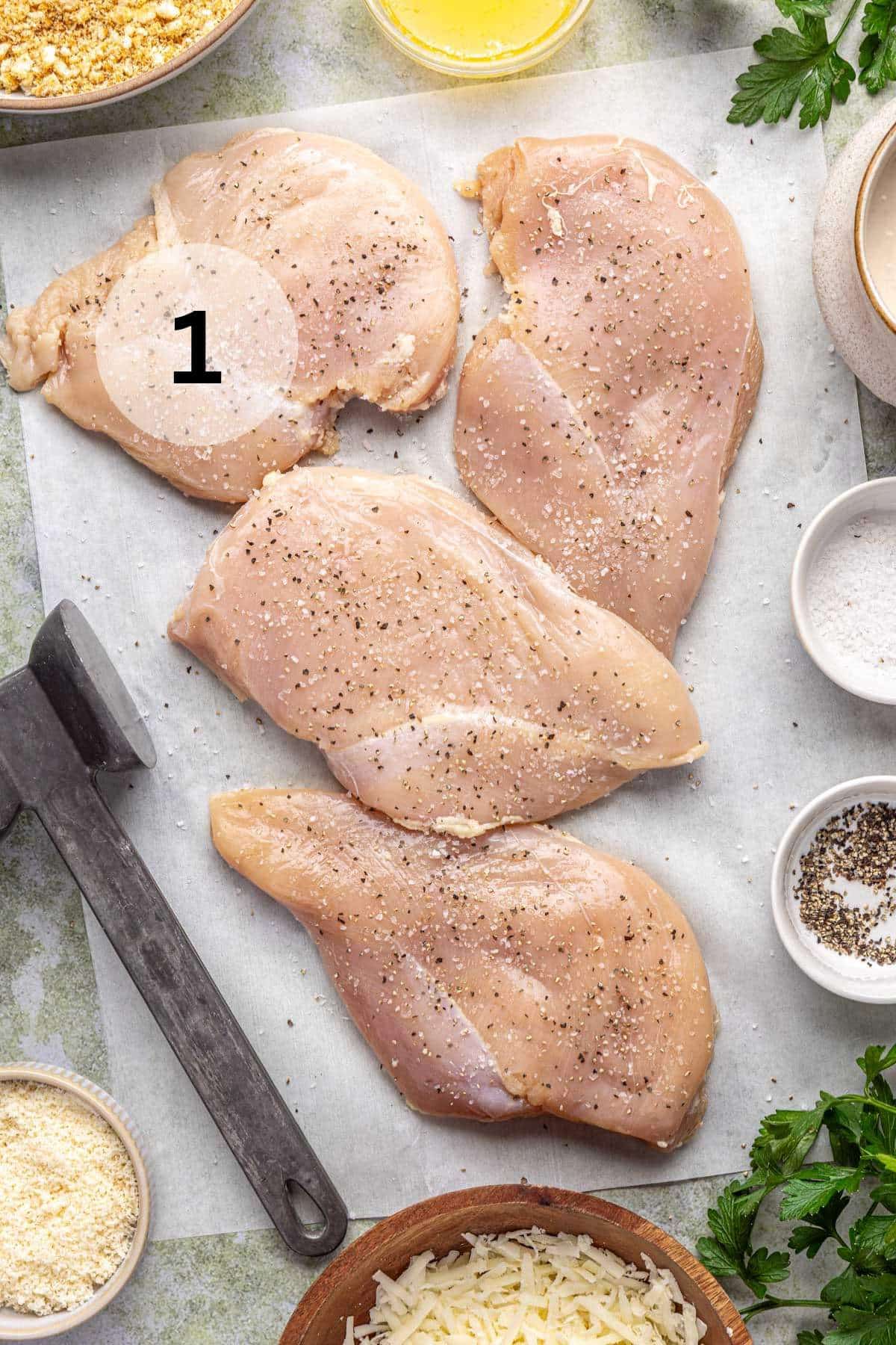 Seasoned chicken breasts on parchment paper.