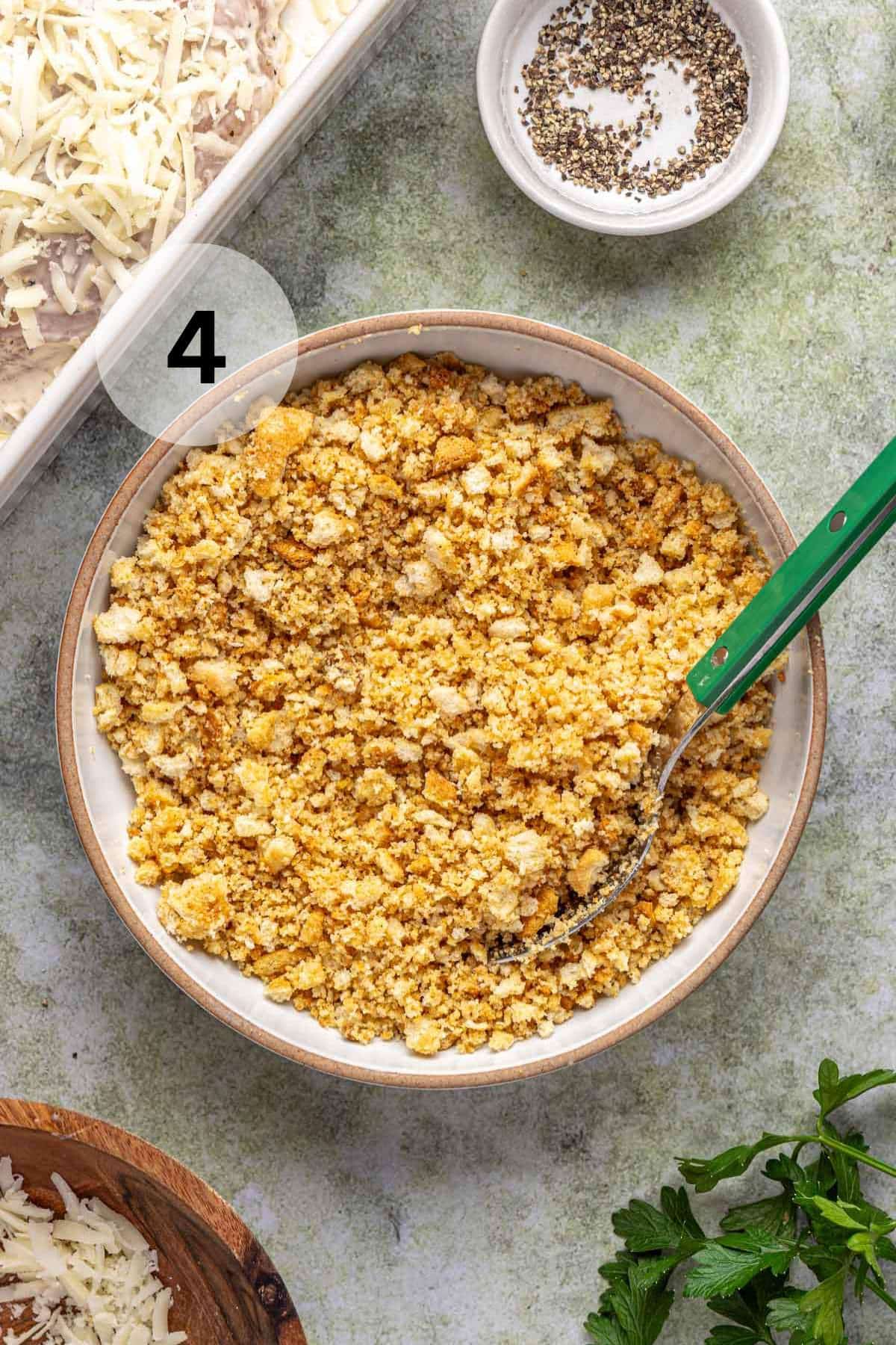 Stirring together crouton crumbs, melted butter and parmesan cheese in a small bowl.