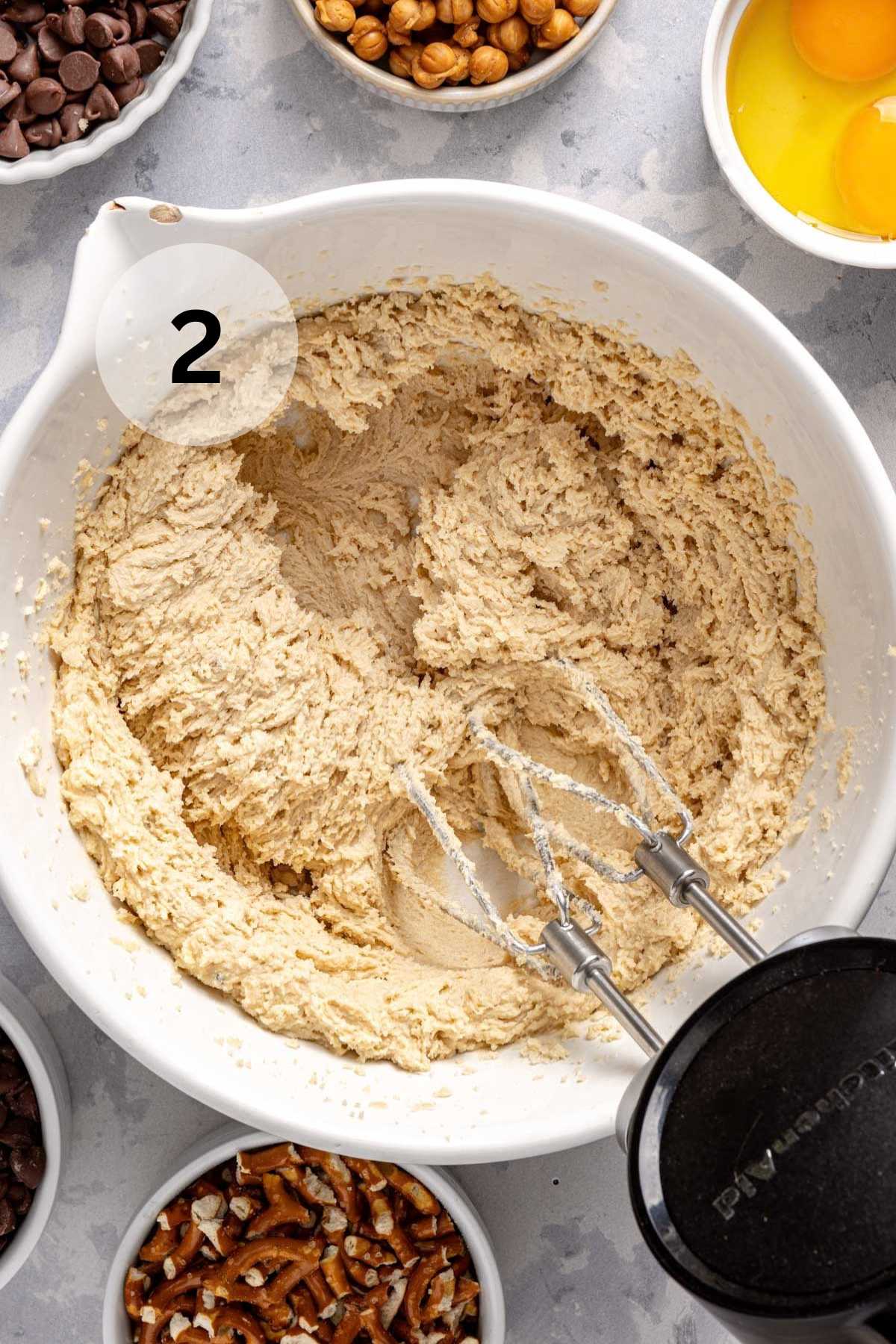 Using a hand mixer to beat sugar and butter together.