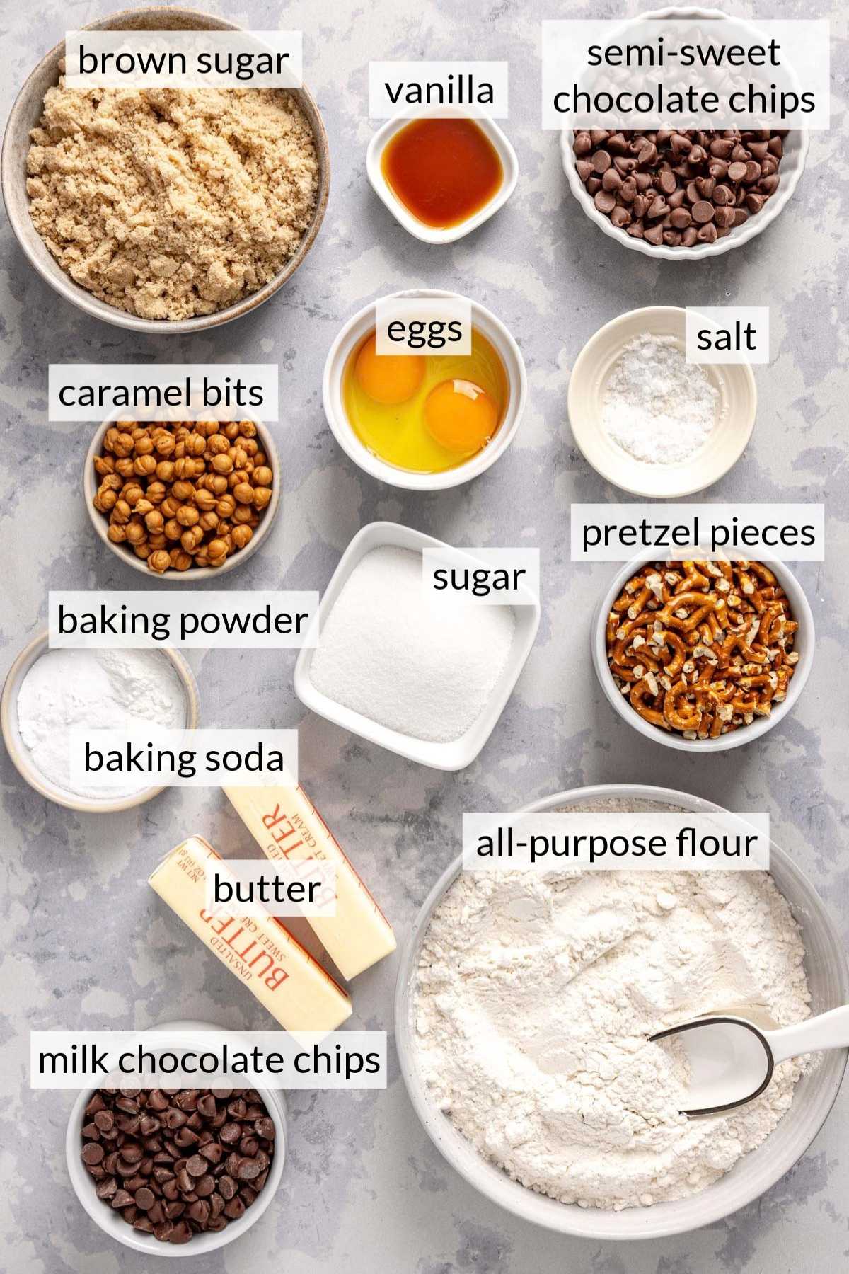 Small bowls with brown sugar, flour, pretzel pieces, chocolate chips and caramel bits.
