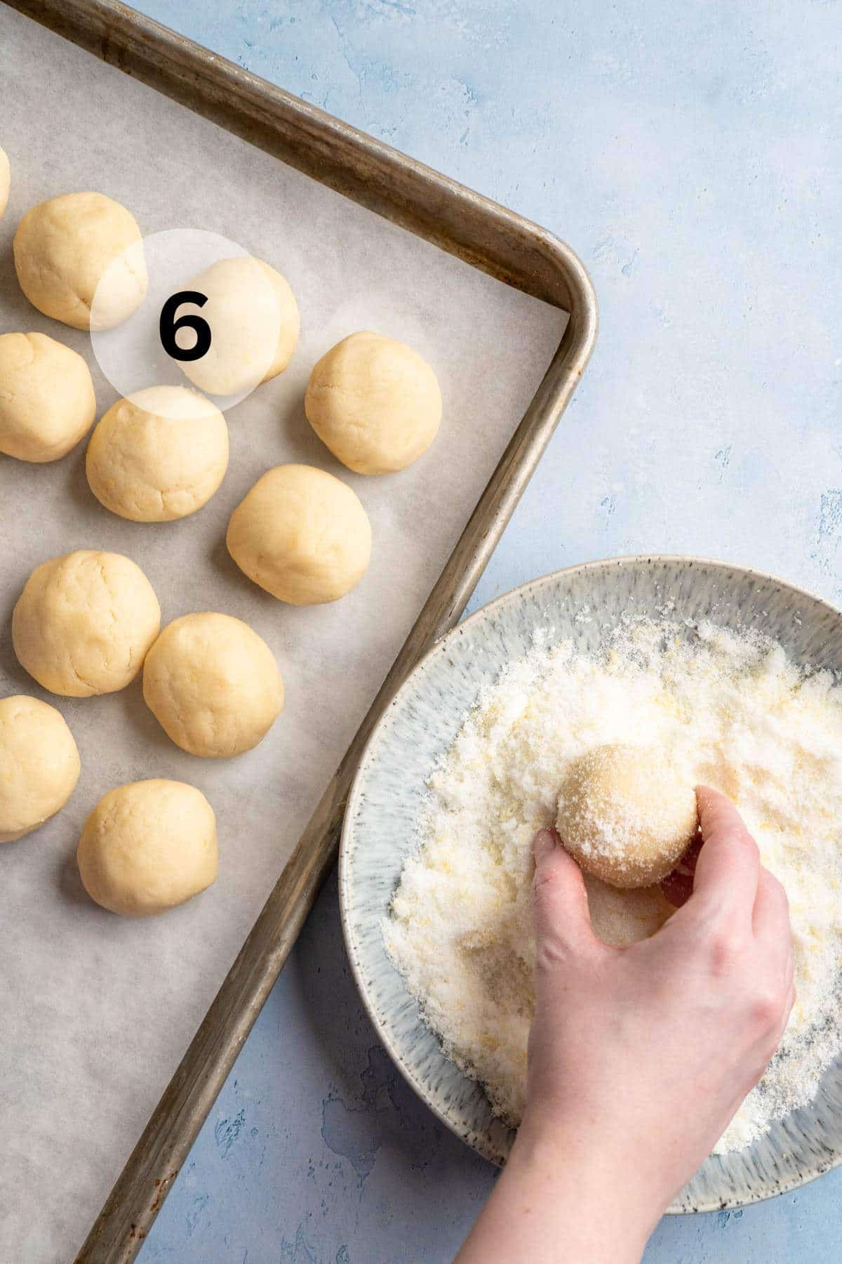 Rolling balls of cookie dough in sugar.