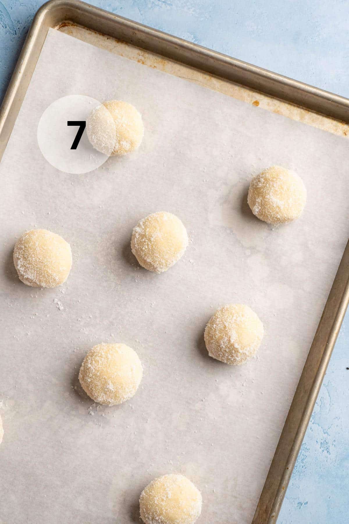 Cookie dough balls on a cookie sheet.