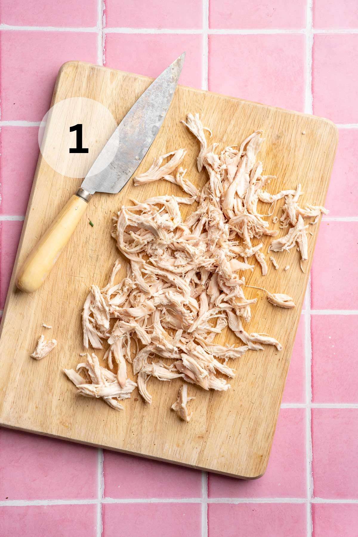 Shredded chicken on a cutting board.