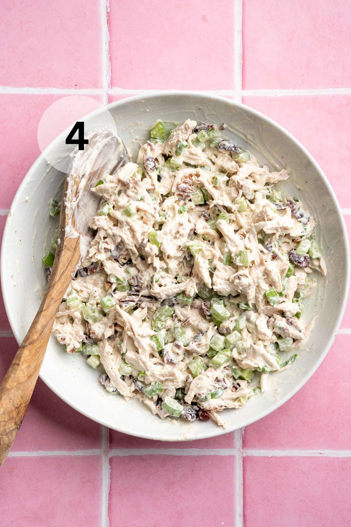 Stirring cranberry chicken salad in a bowl.