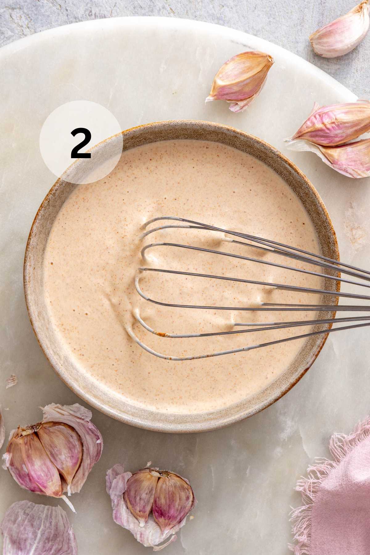 Whisking paprika with water and mayo in a small bowl.
