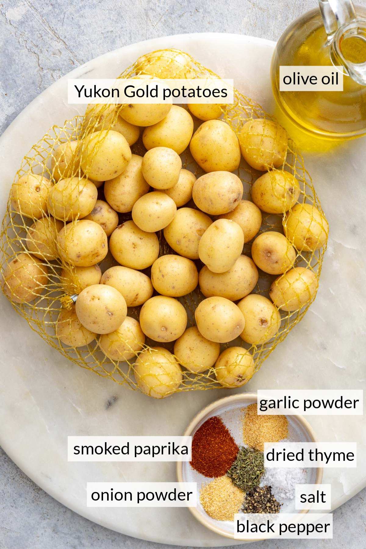 Yukon Gold potatoes near a small plate of seasonings and olive oil.