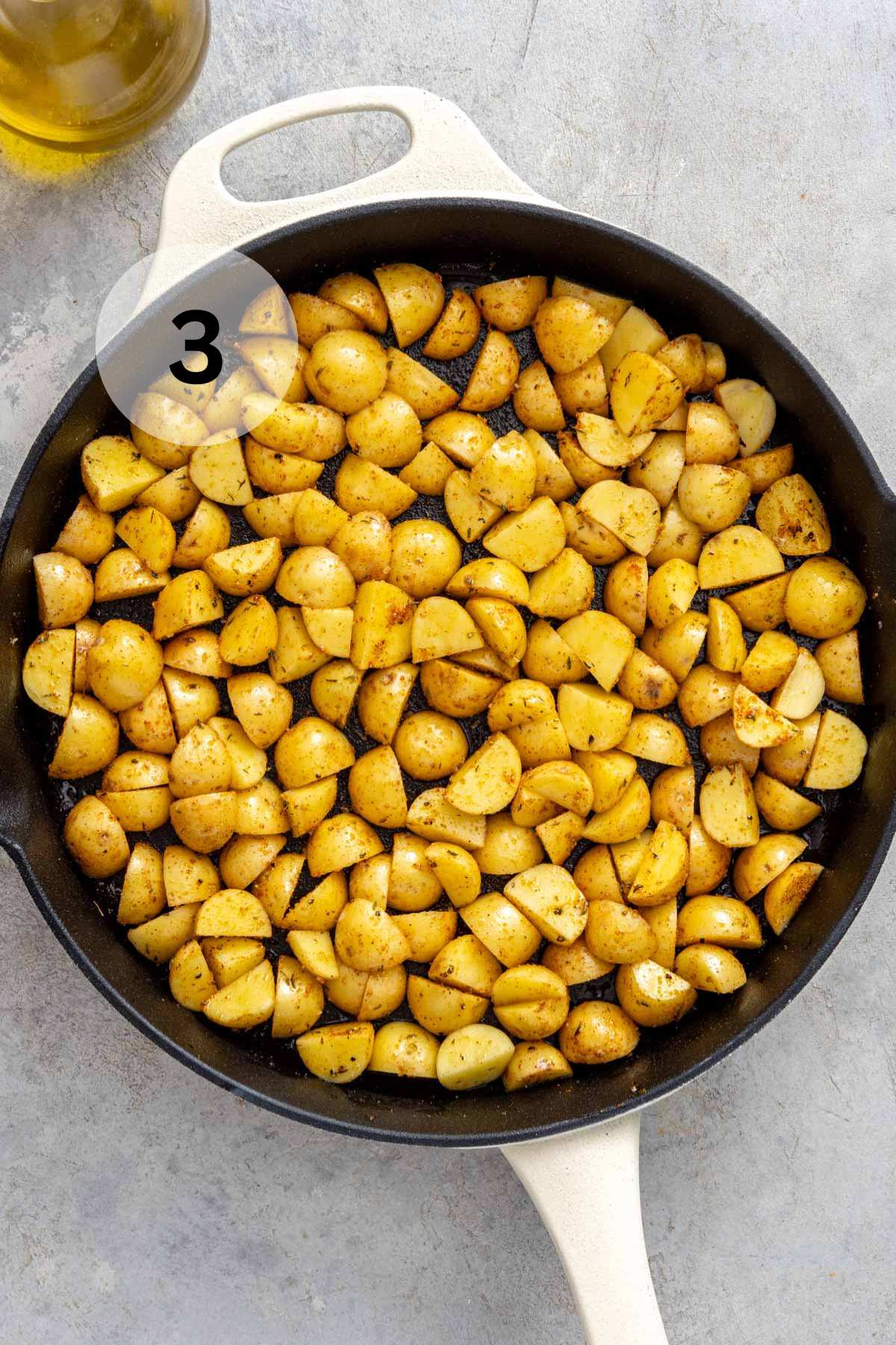 Yukon gold potatoes cooking in an iron skillet.