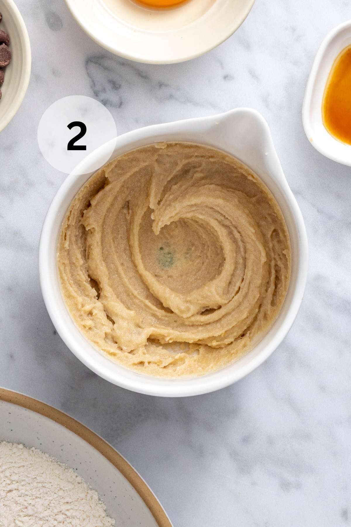 Cookie dough batter combined in a white mixing bowl.