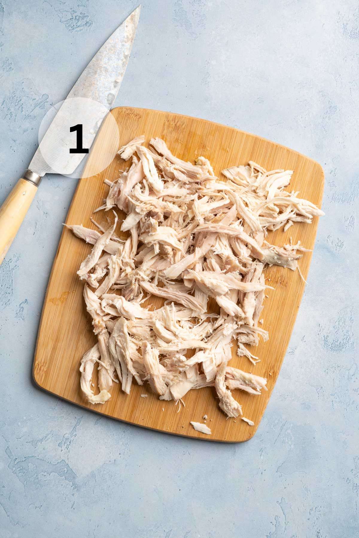 Shredded chicken on a cutting board.