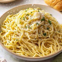 Sprinkling parmesan cheese over buttered noodles.