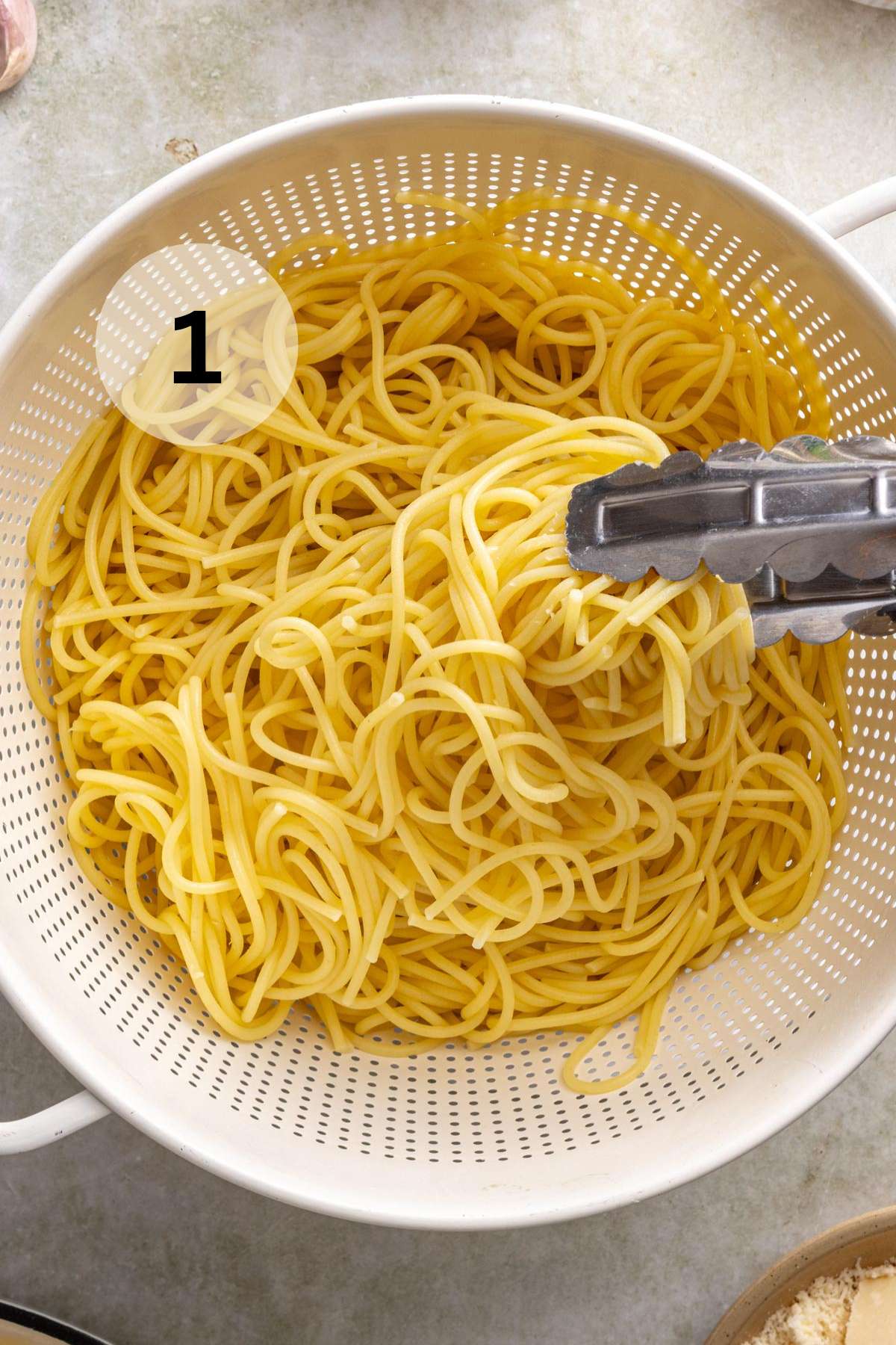 Draining spaghetti in a colander.