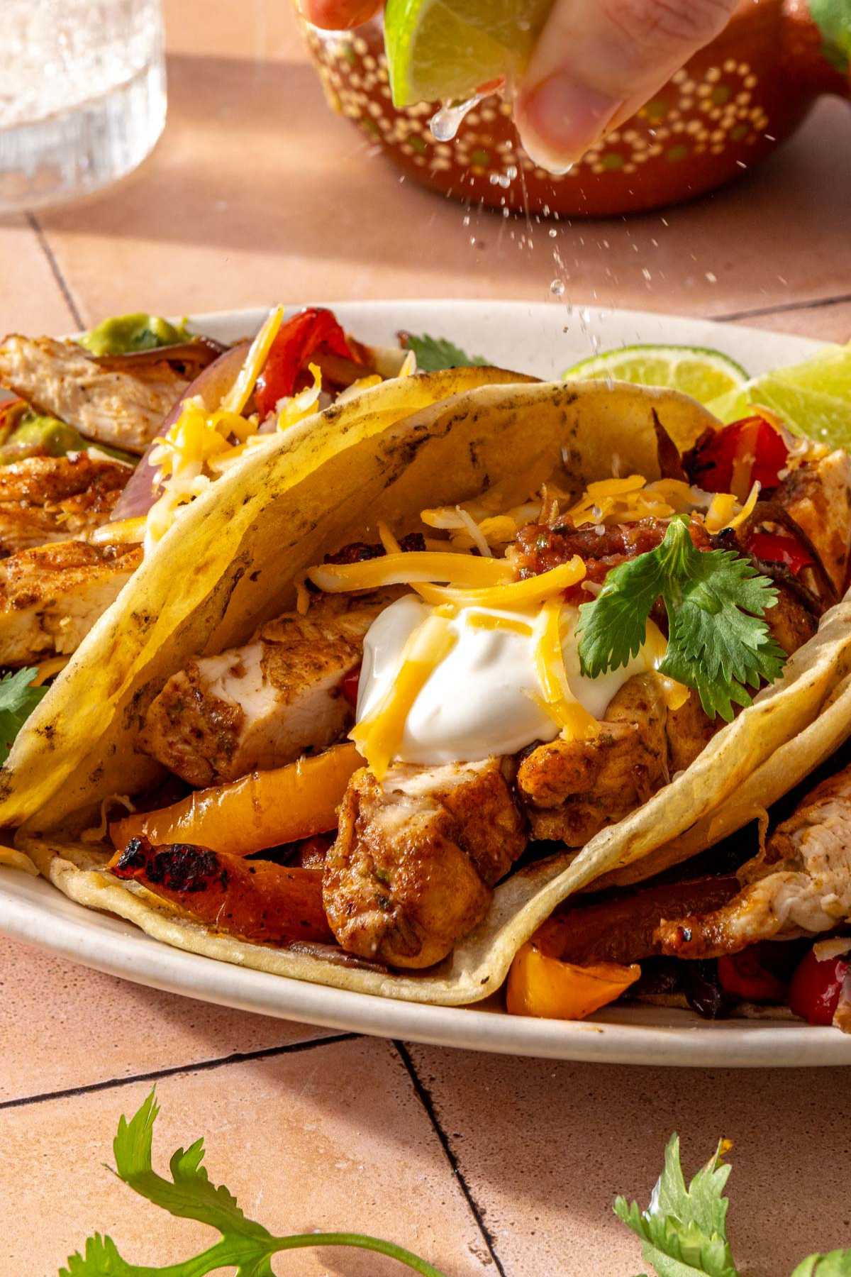 Squeezing lime juice over a chicken fajitas.
