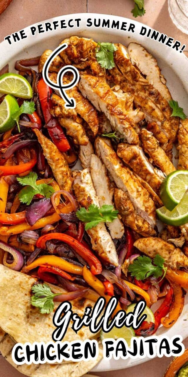 Sliced fajita chicken on a large plate with sautéed veggies, tortillas and lime wedges.