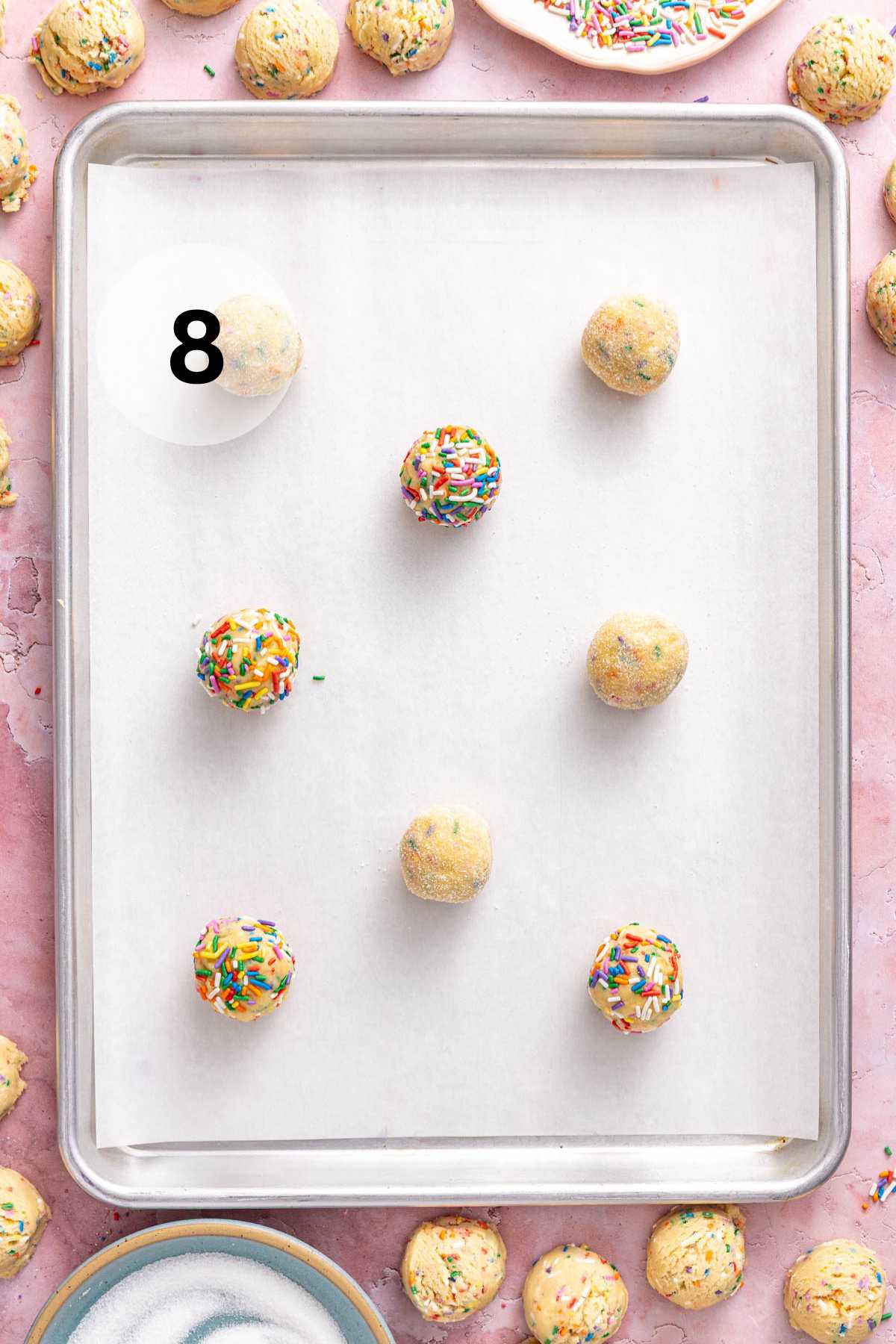 Cookie dough balls on a parchment lined cookie sheet.