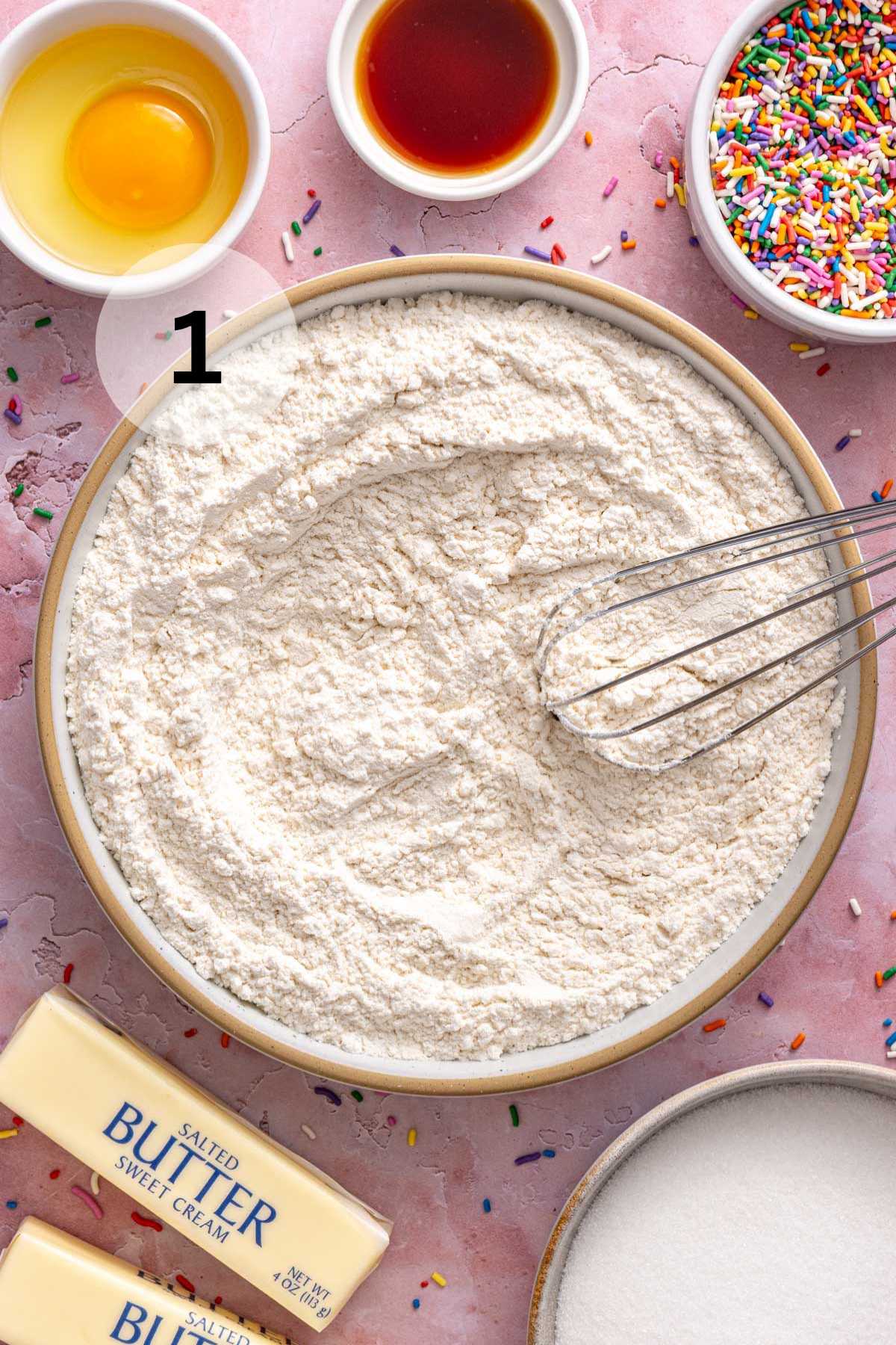 Whisking flour with baking soda, baking powder, and salt.
