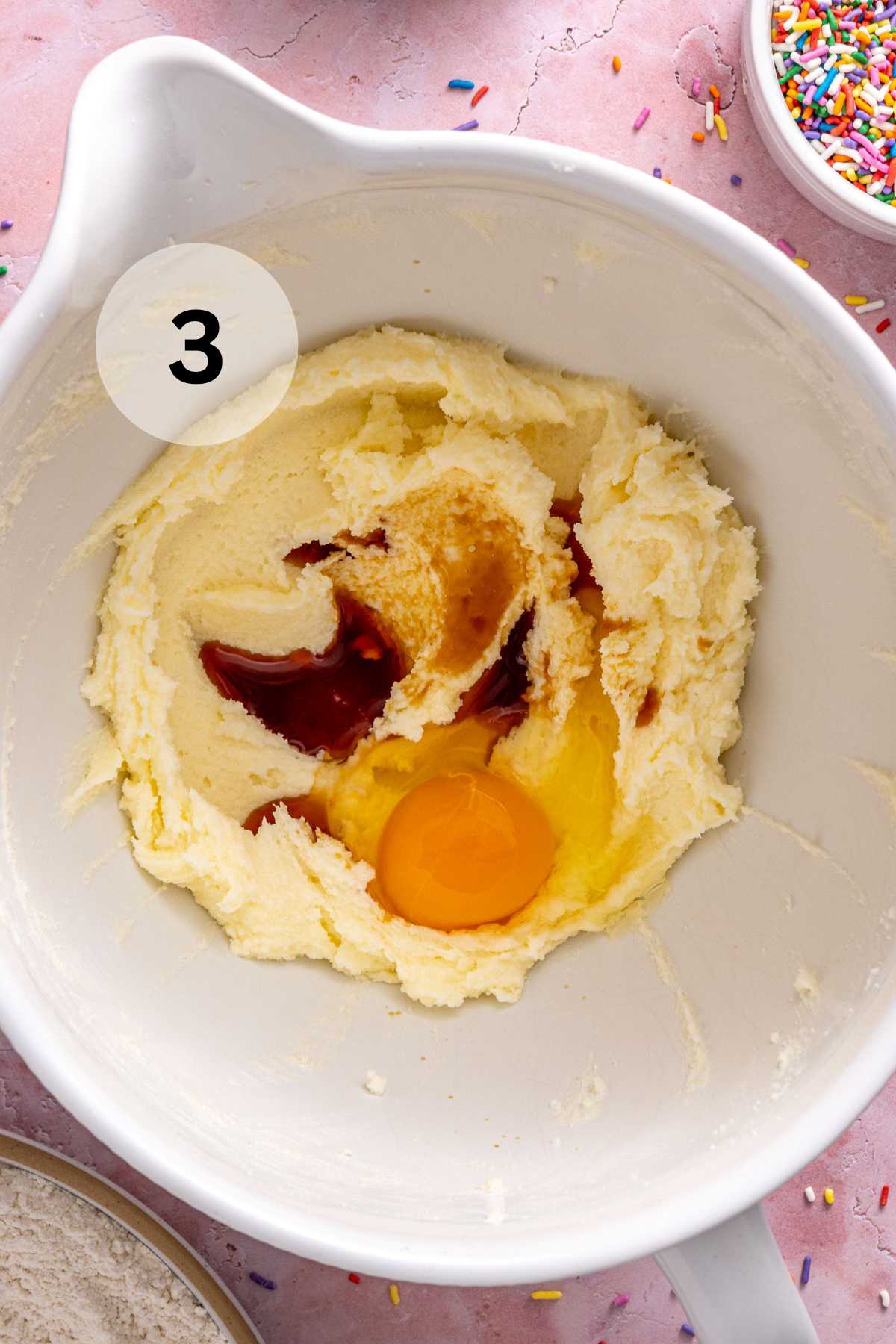Adding eggs and vanilla to butter and sugar mixture.