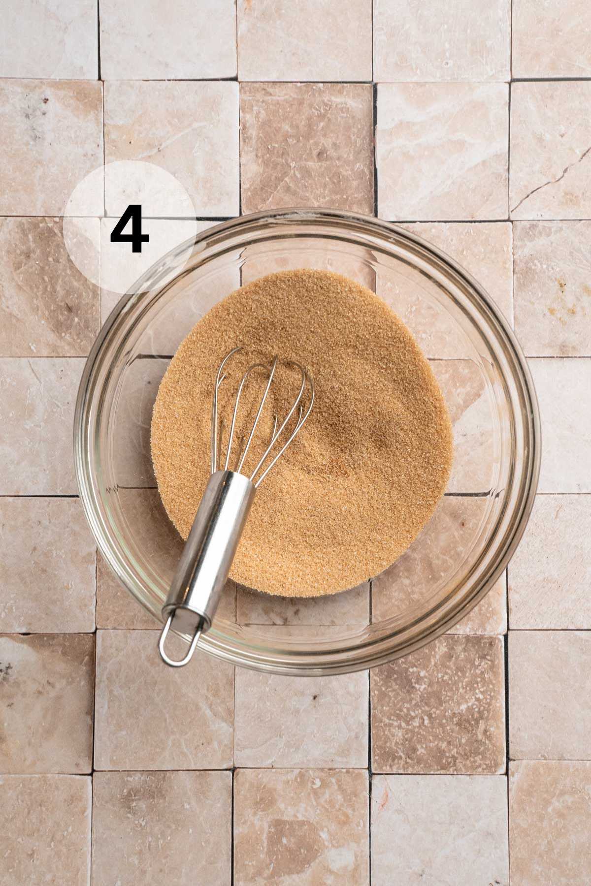 Whisking sugar and cinnamon in a small bowl.